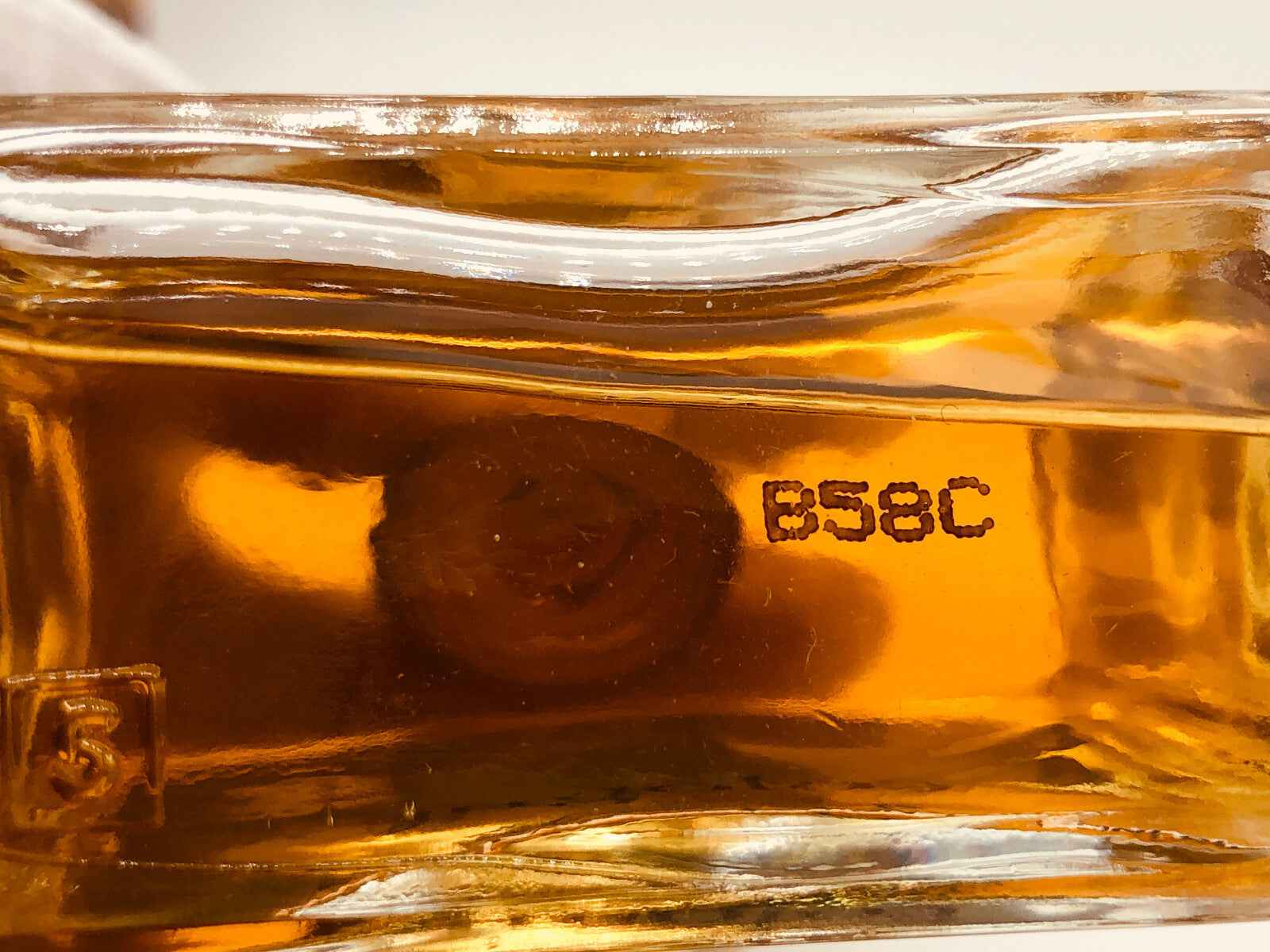 Dettaglio del fondo della bottiglia di profumo Aramis Cologne Vintage con codice di produzione