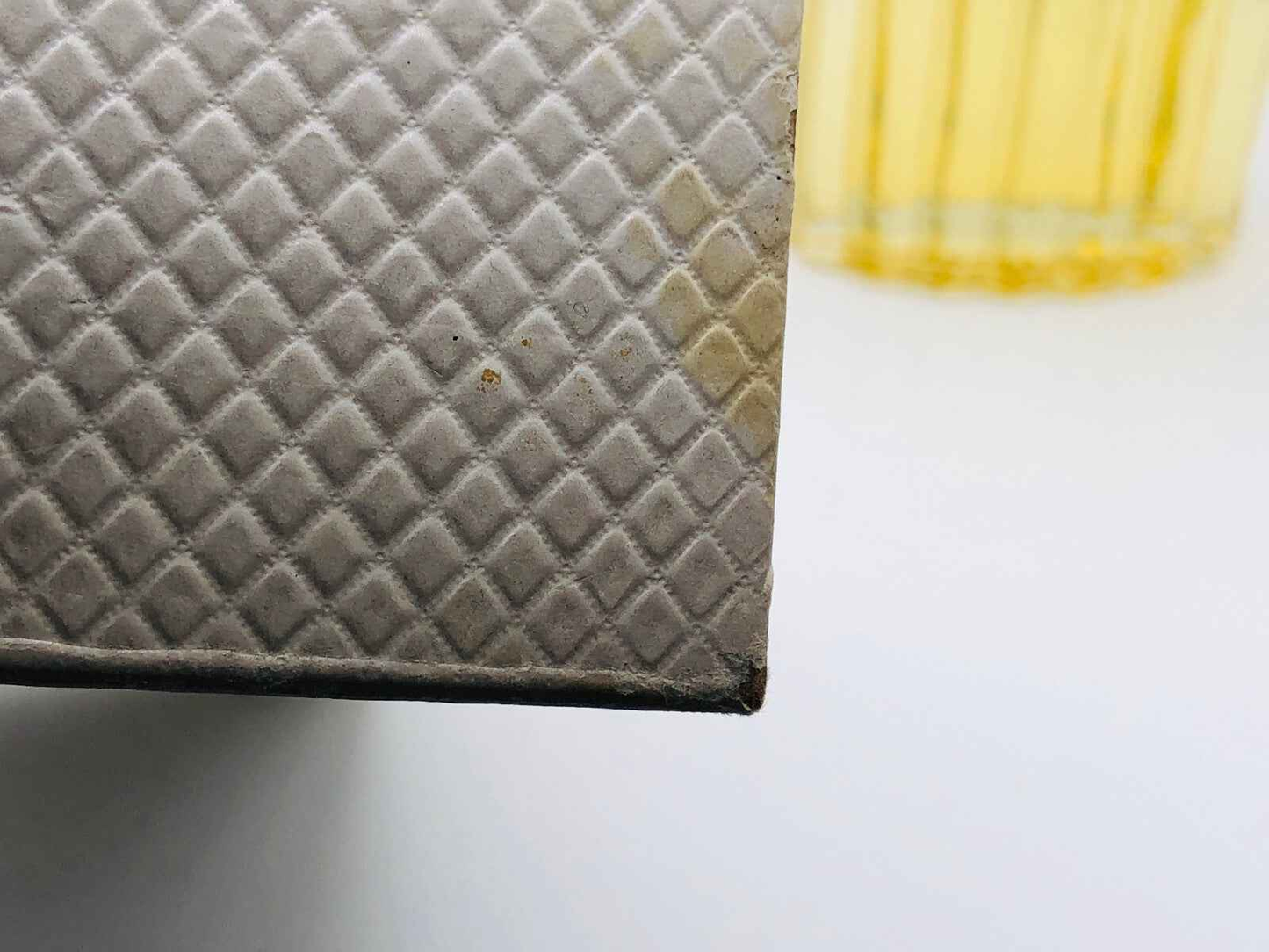 Dettaglio della confezione del profumo Balenciaga Fleeting Moment con texture unica e colore soffuso