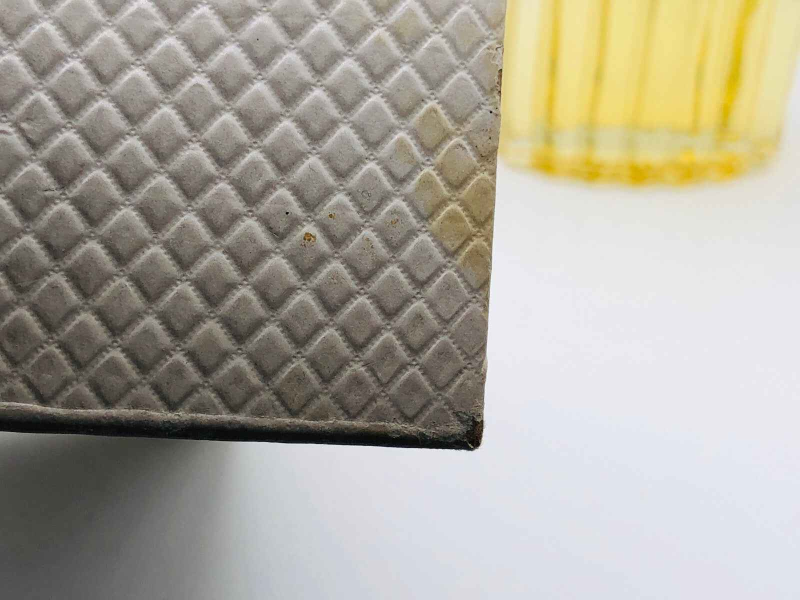 Dettaglio della confezione del profumo Balenciaga Fleeting Moment con texture unica e colore soffuso