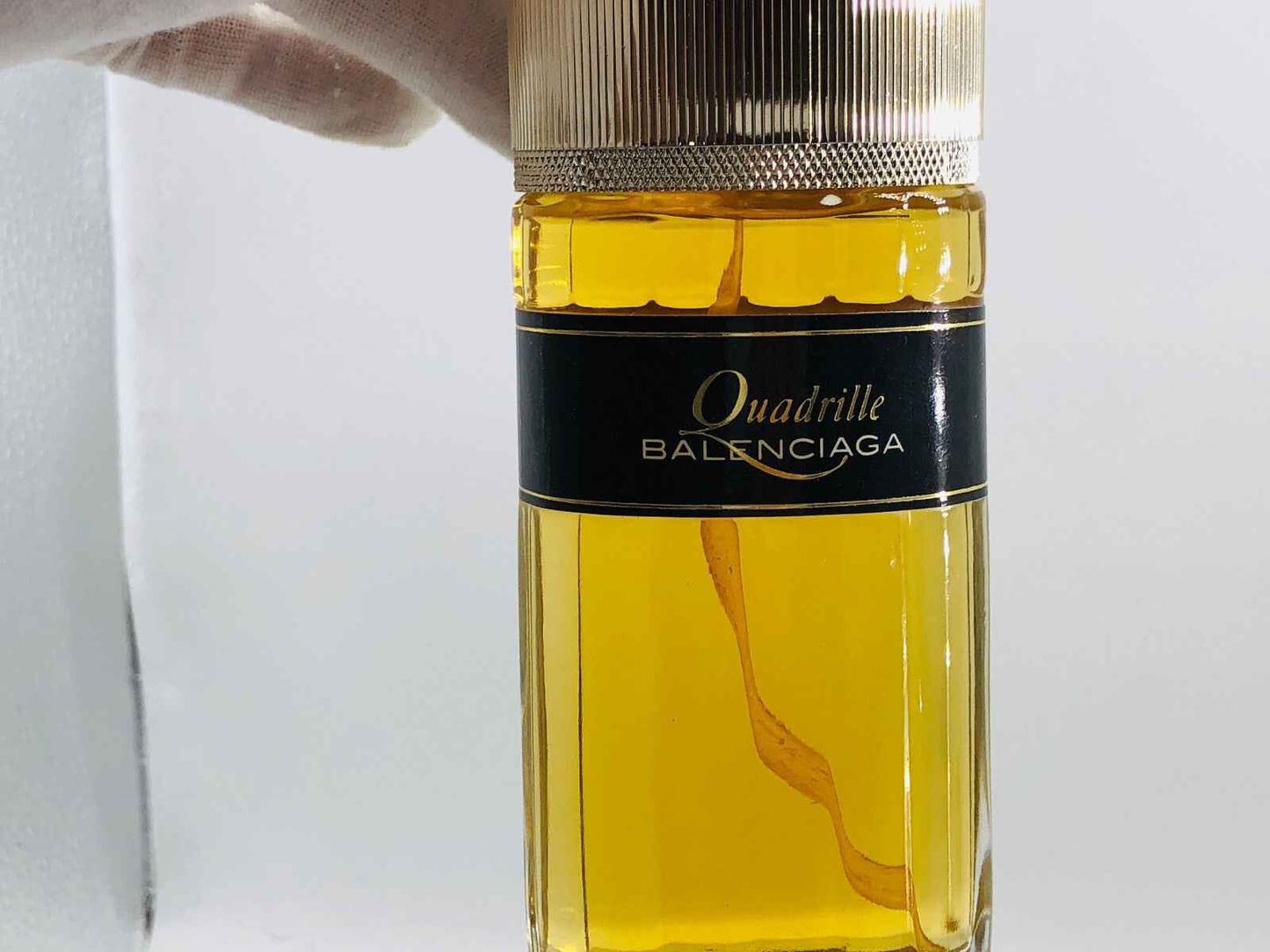 Flacone di profumo Balenciaga Quadrille con elegante tappo dorato e liquido giallo