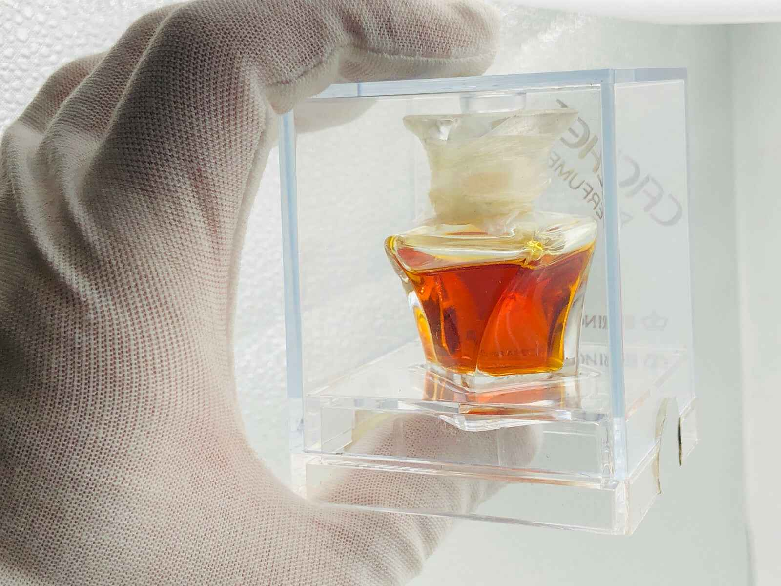 Flacone di profumo Cachet Prince Matchabelli con liquido ambrato in esposizione elegante