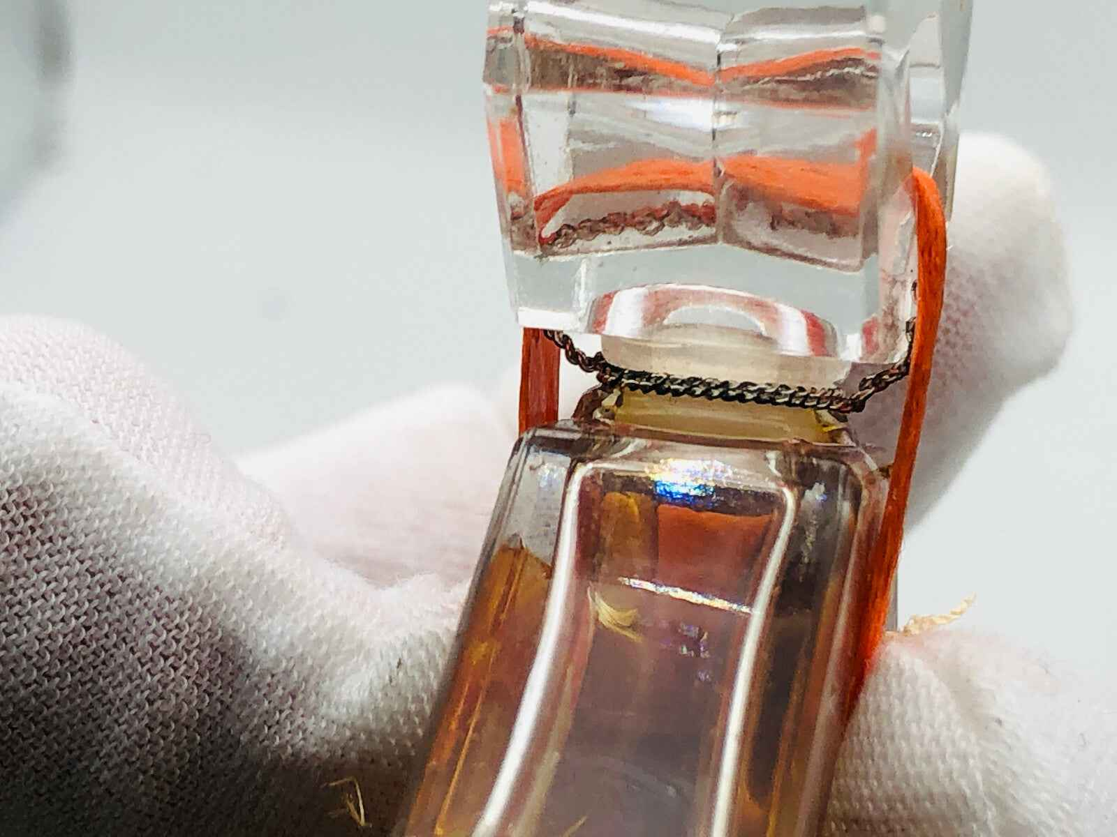 Flacone di profumo Infini Caron con design elegante e dettagli raffinati, tenuto delicatamente