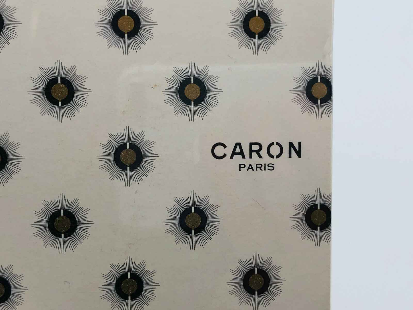 Packaging elegante di Caron Muguet Du Bonheur con design floreale distintivo e logo Caron