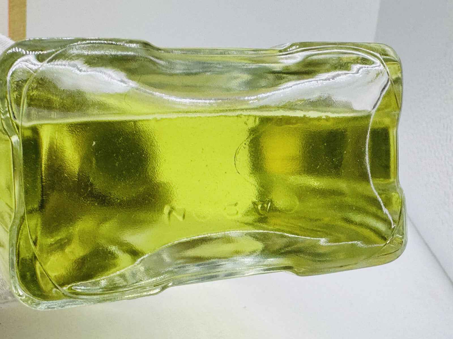 Bottiglia di profumo Caron Pour Un Homme con liquido giallo brillante e design elegante