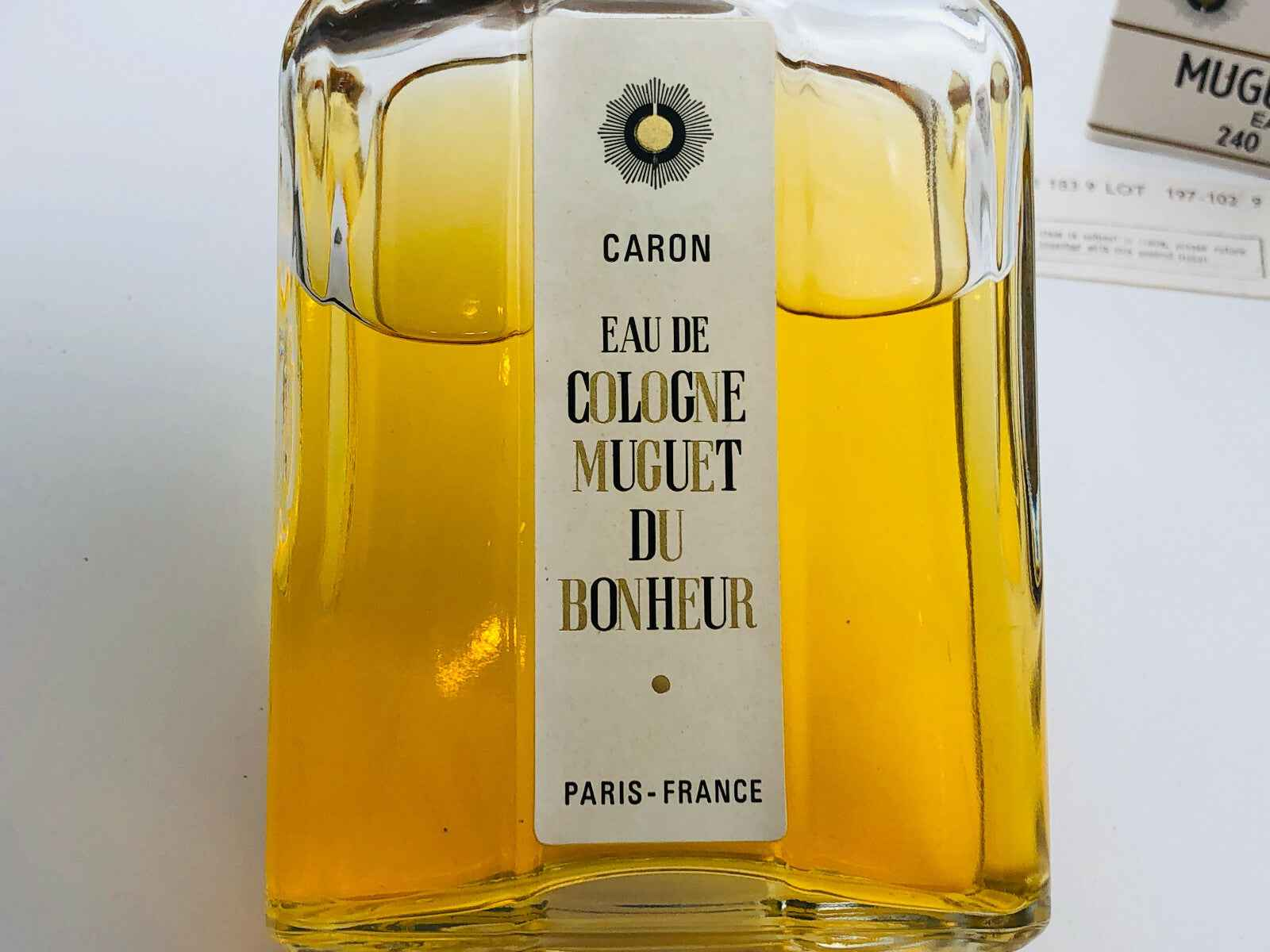 Bottiglia di Eau de Cologne Muguet du Bonheur di Caron, un profumo vintage Caron dal carattere unico
