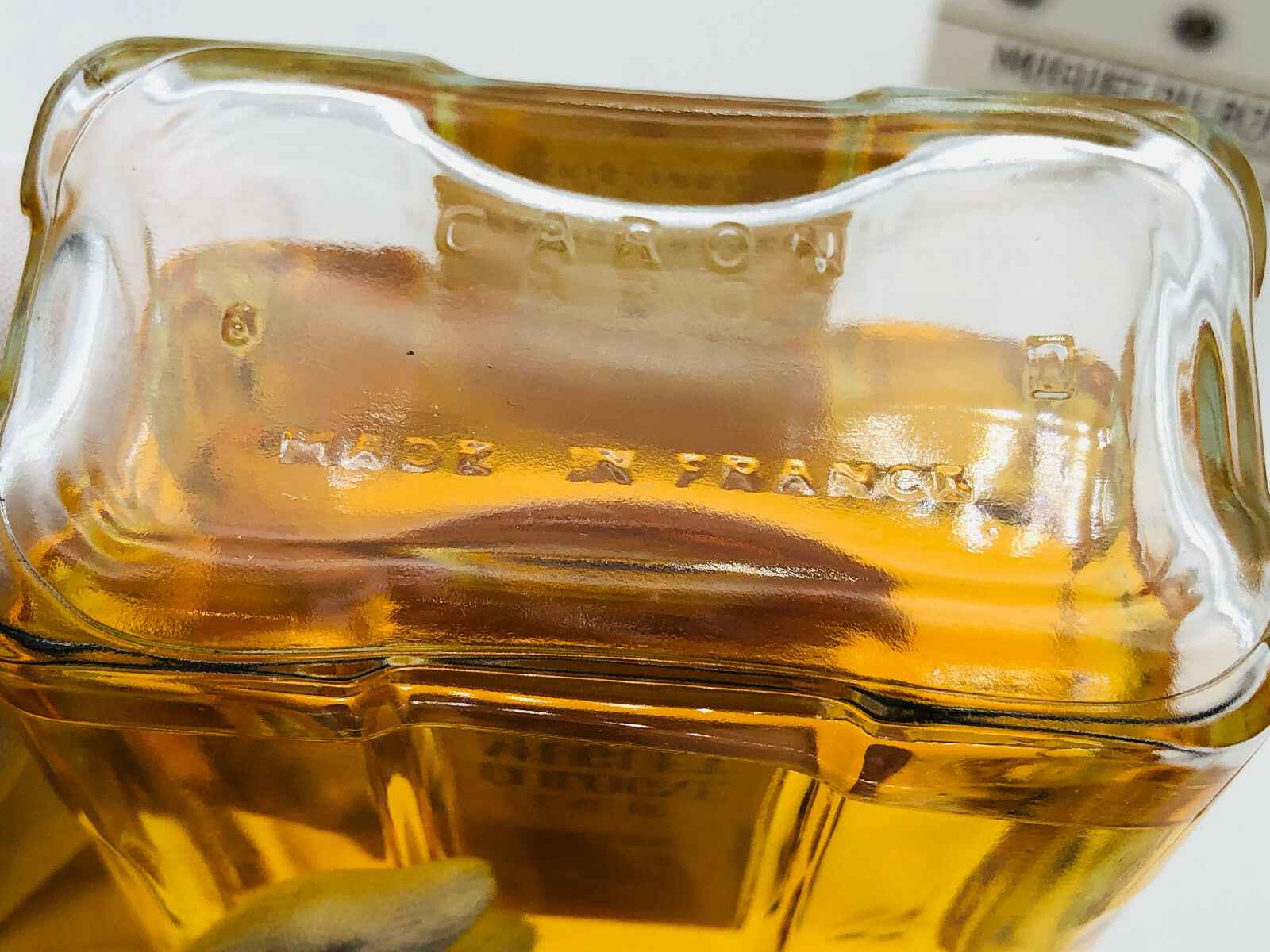 Dettaglio della bottiglia di profumo Vintage Caron con incisione Made in France sul fondo