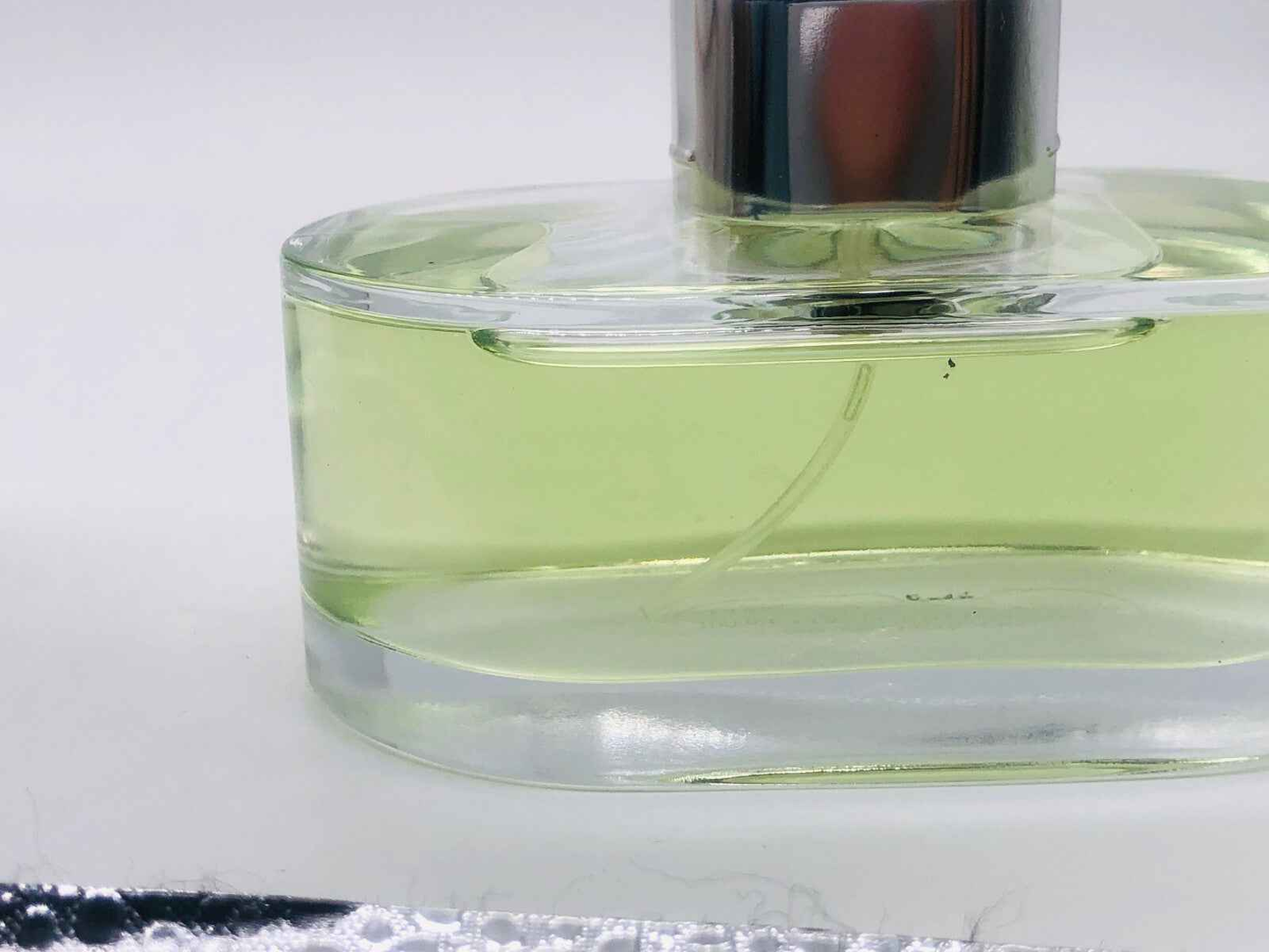 Profumo Must Pour Homme Cartier Vintage con bottiglia trasparente e liquido verde chiaro