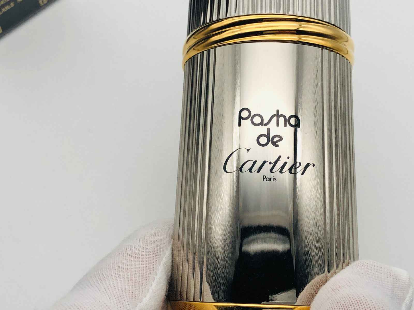 Flacone di profumo Pasha Cartier in metallo lucido con finiture dorate e design elegante