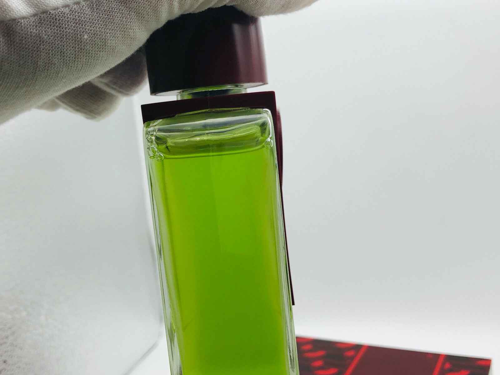 Profumo Carven Monsieur Vintage in bottiglia verde con tappo bordeaux, elegante e raffinato.