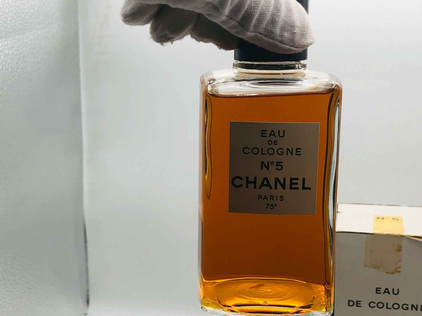 Flacone di Profumo Chanel N 5 Vintage con etichetta elegante in una mano guantata