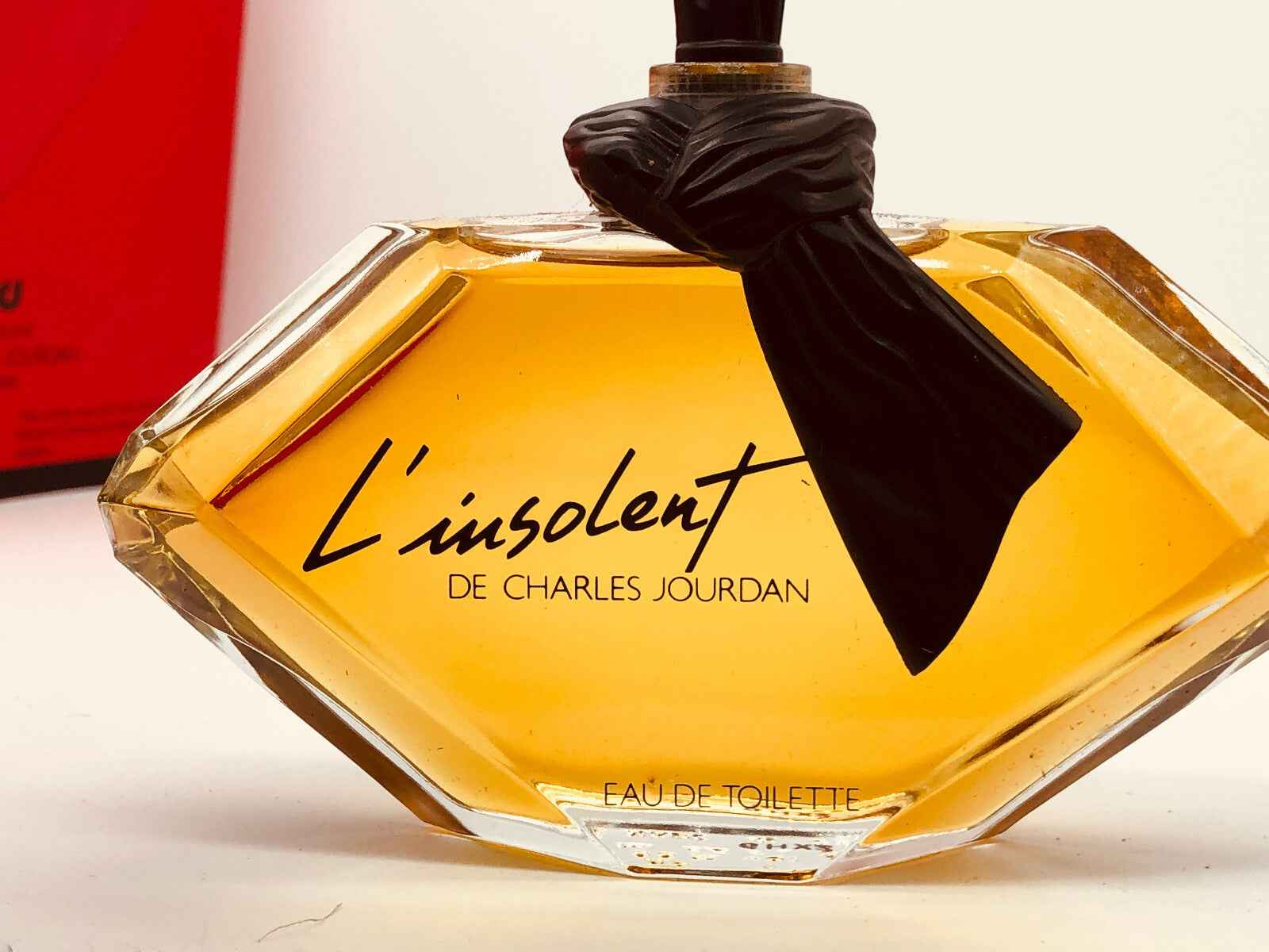 Profumo L'insolent Charles Jourdan in bottiglia elegante con tonalità dorata e fiocco nero