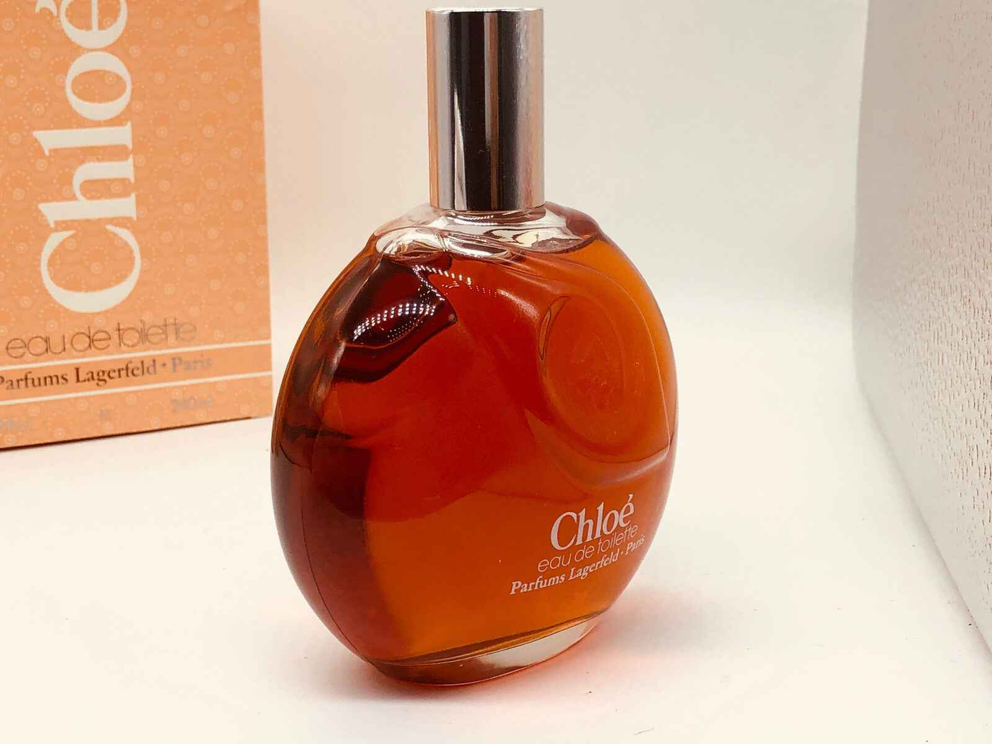 Profumo Chloé Karl Lagerfeld Vintage in flacone ovalo con tonalità calde, rappresenta eleganza senza tempo