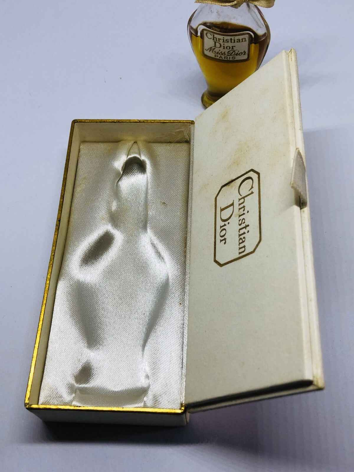 Astuccio dorato di profumo Miss Dior Amphore con design elegante in satin bianco