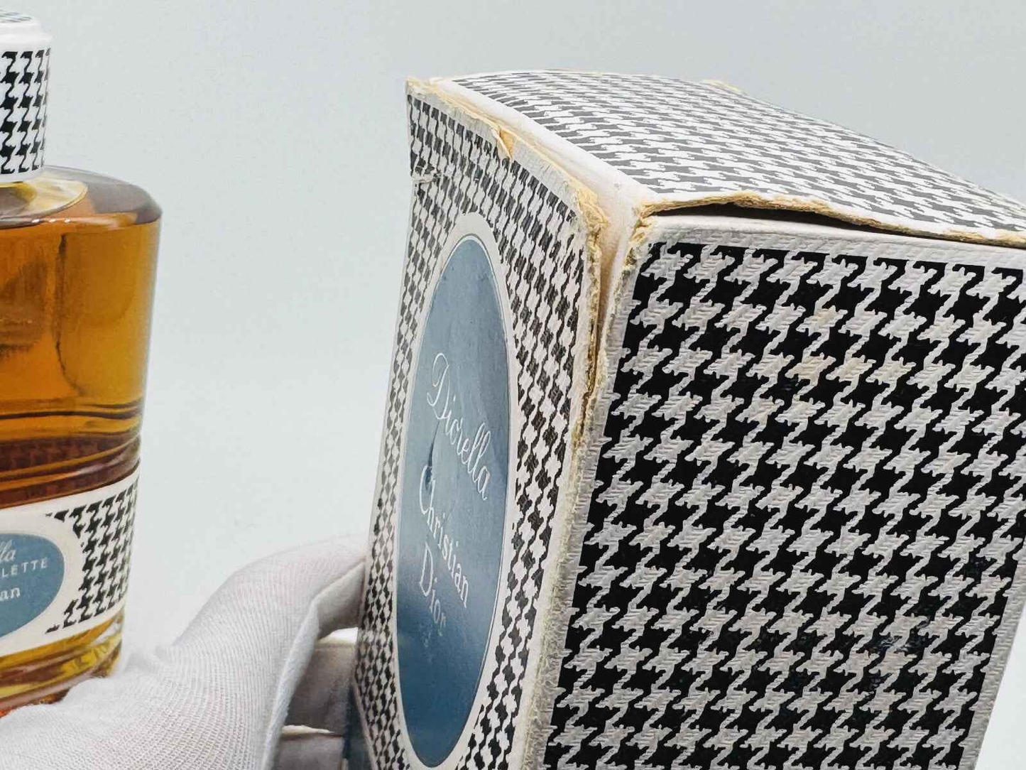 Profumo Diorella Vintage in bottiglia con confezione a motivo pied de poule elegante