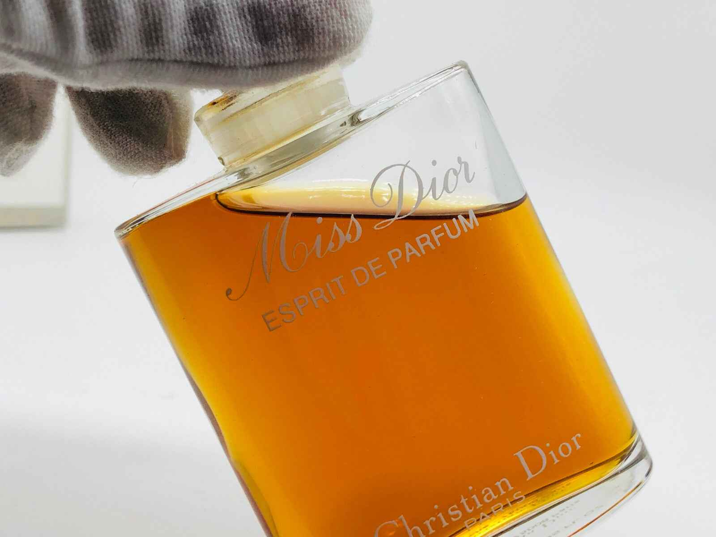 Flacone di profumo Miss Dior Vintage con liquido ambrato e design elegante