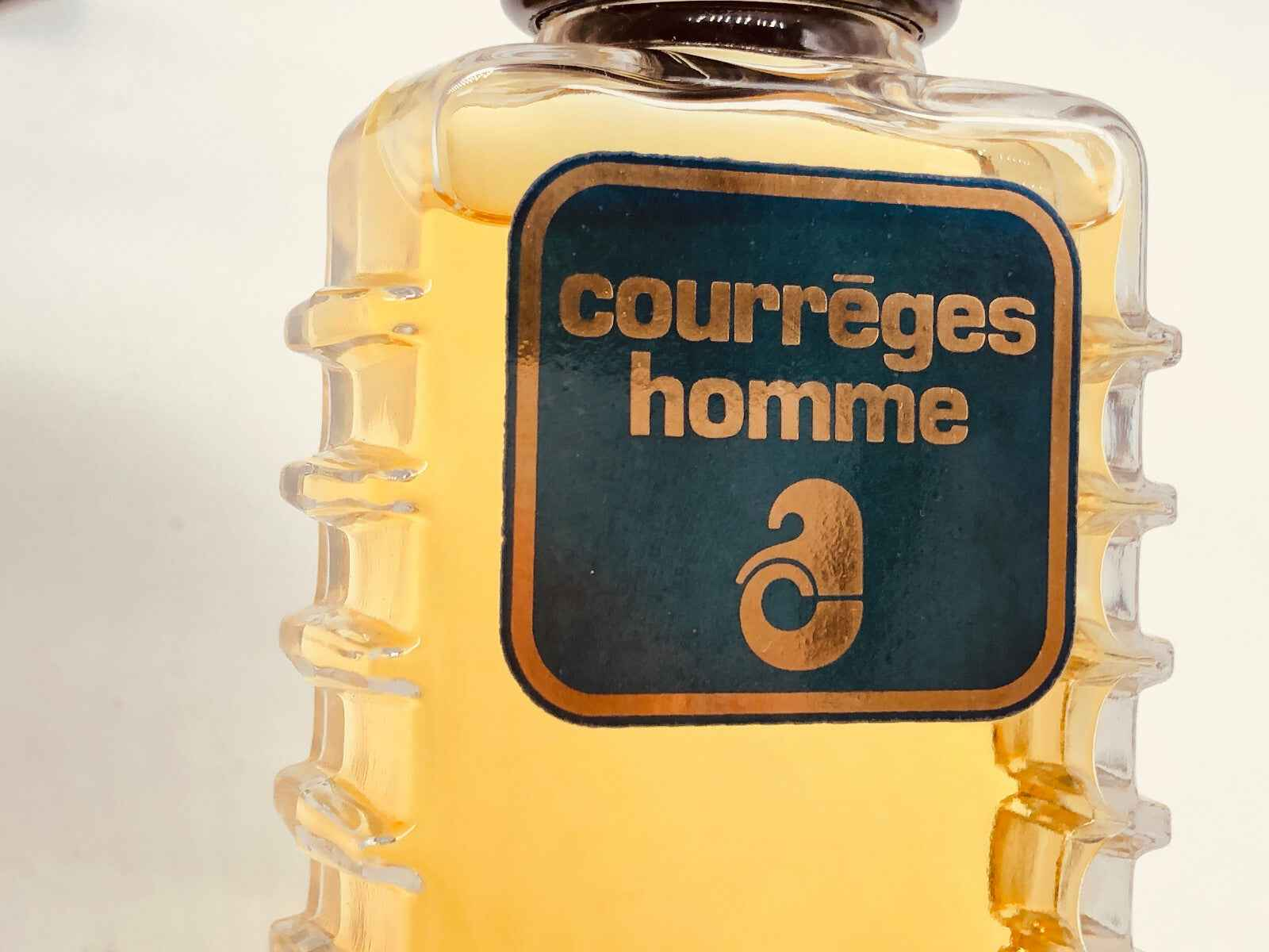 Profumo Vintage Courreges Homme in bottiglia trasparente con etichetta blu e oro