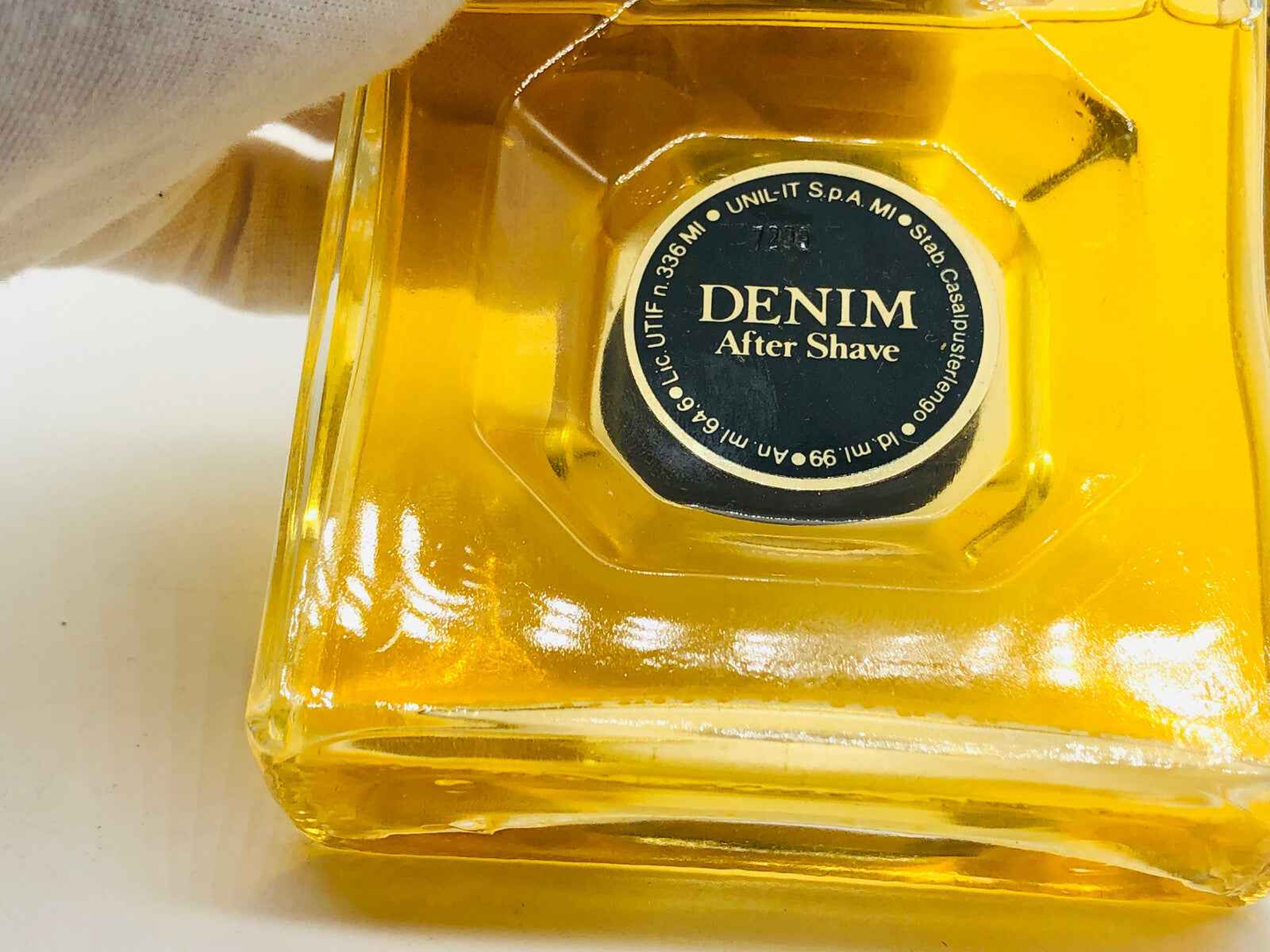 Profumo Denim Original Vintage in flacone di dopobarba con etichetta nera e liquido giallo