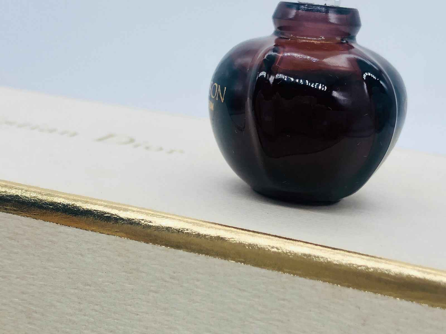 Bottiglia di profumo Dior La Collection Parfum su sfondo elegante con dettagli dorati