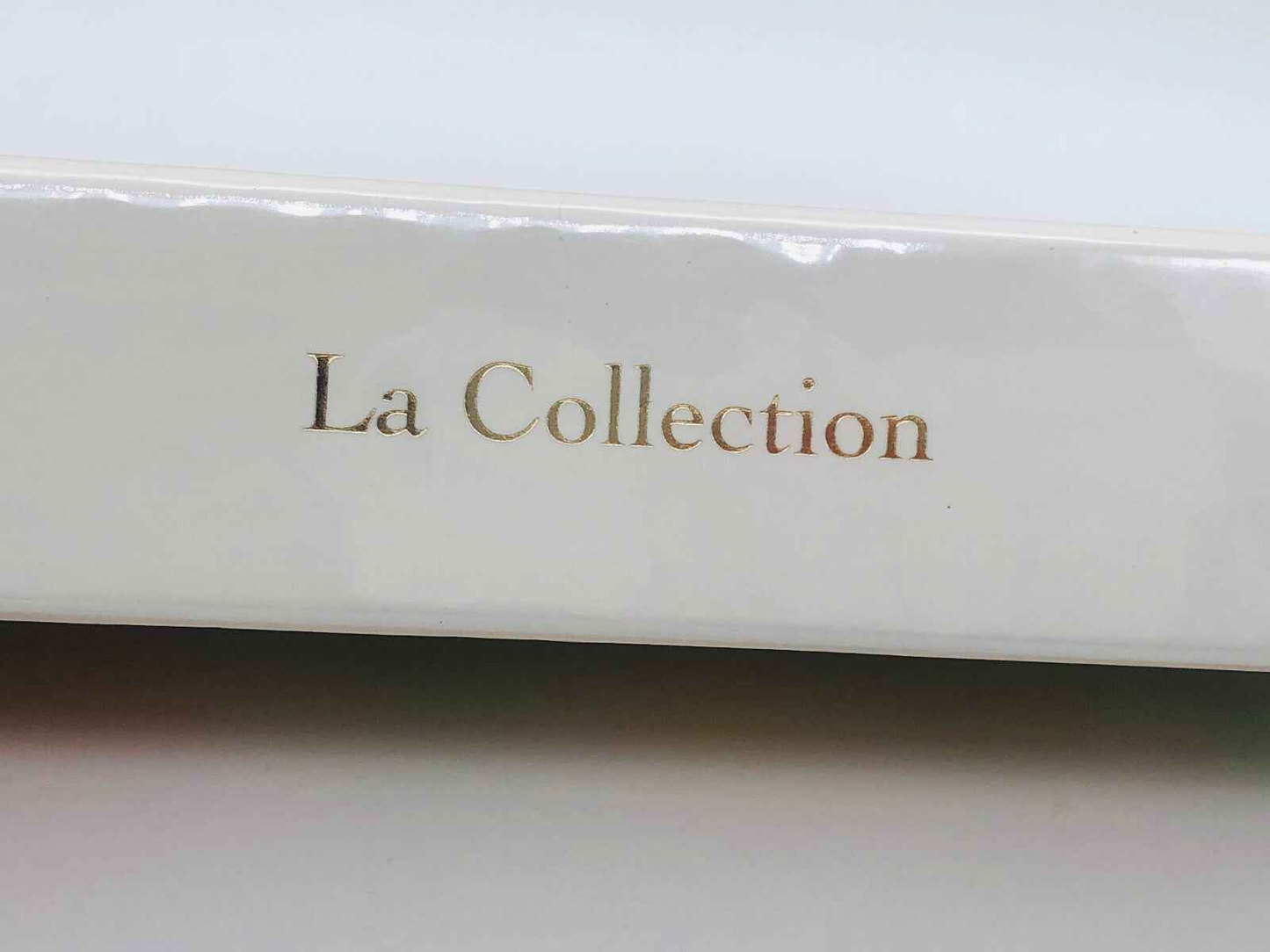 Dior La Collection in eleganti caratteri dorati su copertura bianca per profumi di lusso