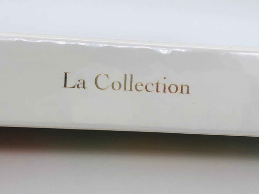 Dior La Collection in eleganti caratteri dorati su copertura bianca per profumi di lusso