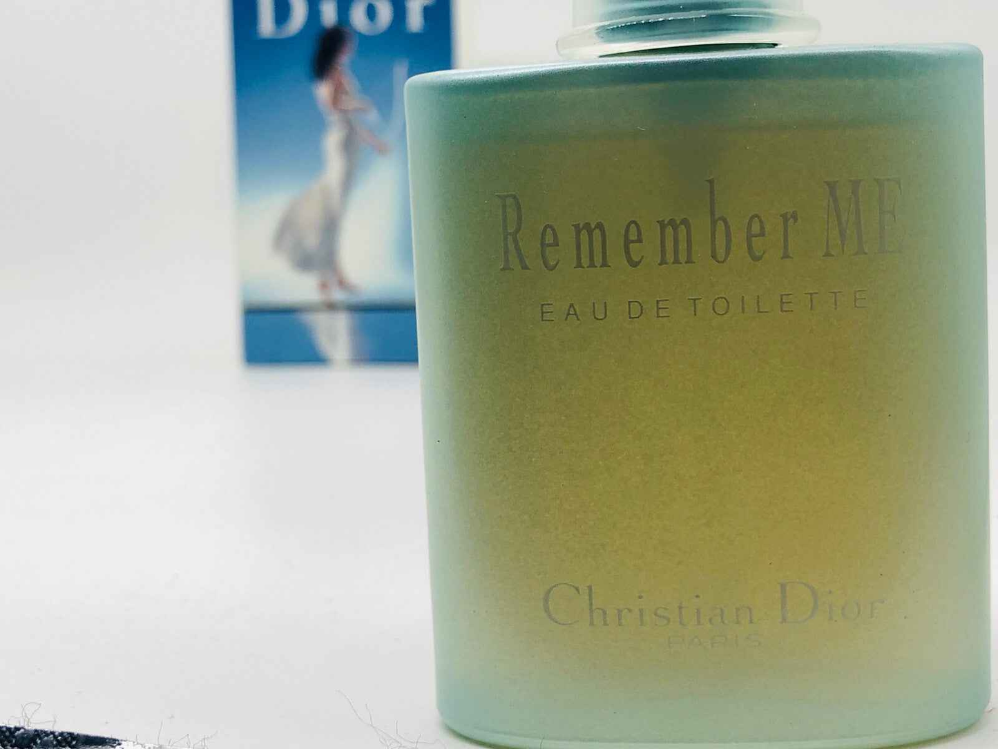 Profumo Remember Me Dior in flacone verde con etichetta elegante e sfondo della confezione