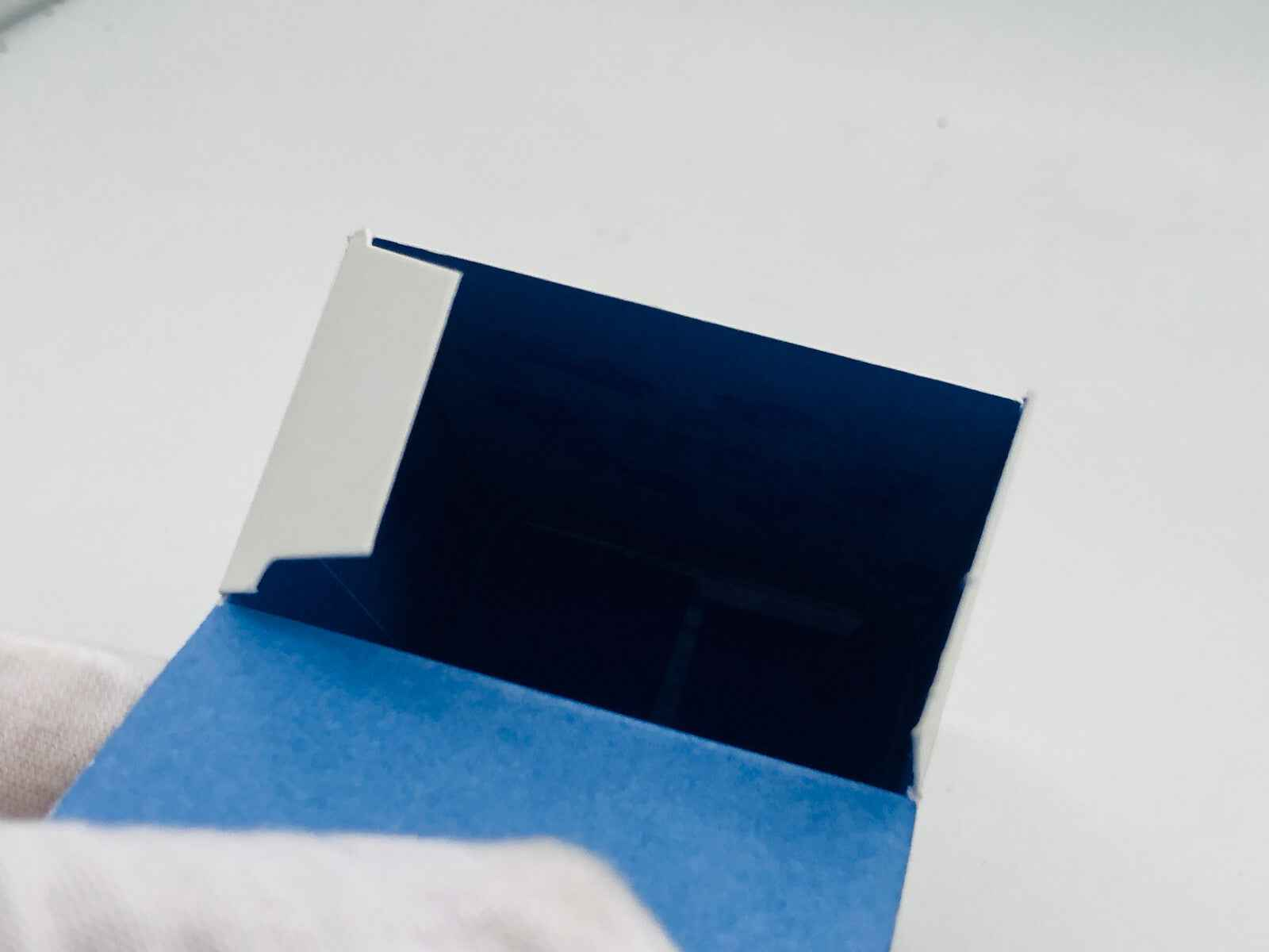 Scatola aperta del profumo Remember Me Dior con interno blu elegante e design minimalista