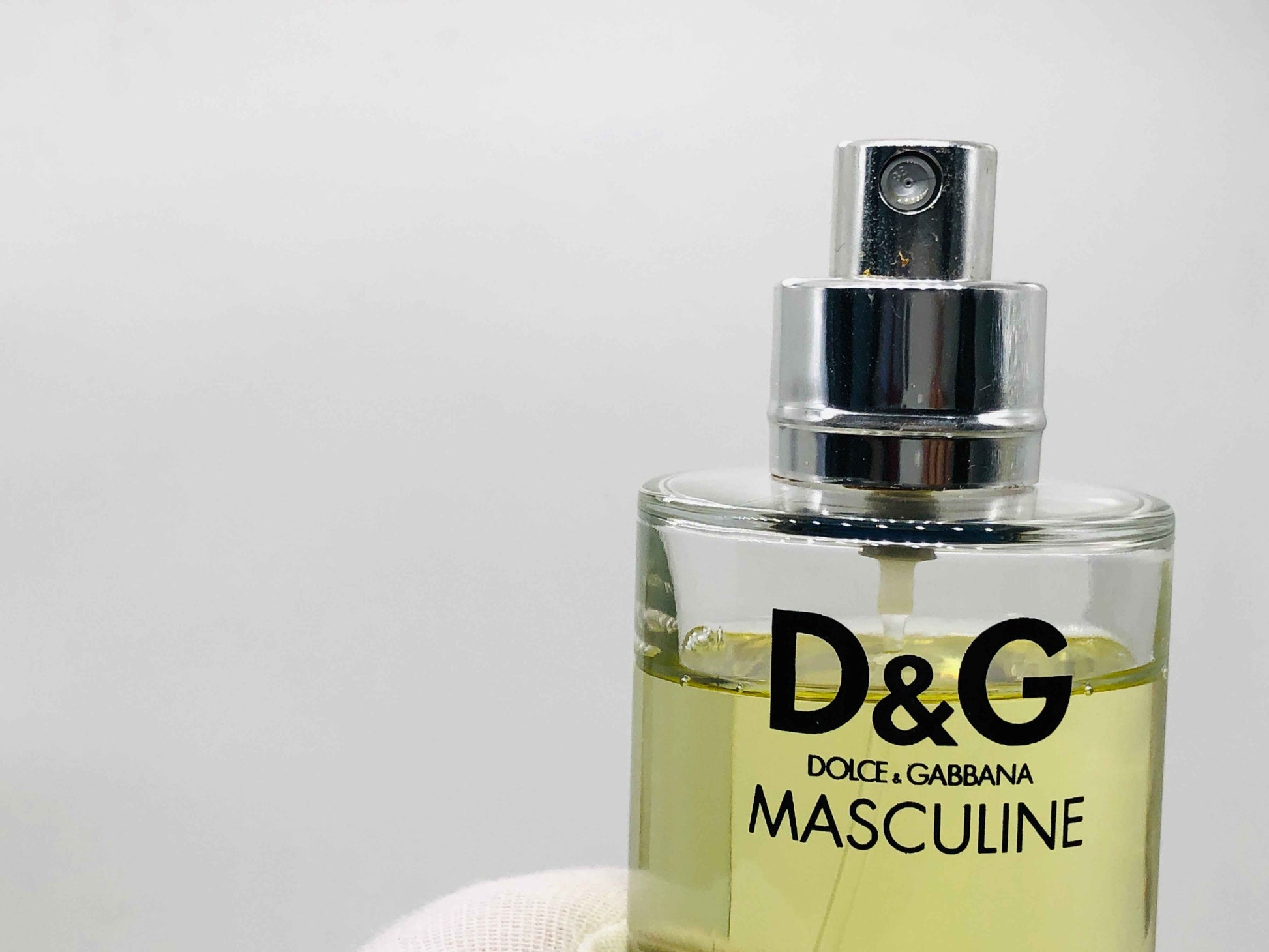 Flacone di profumo Dolce E Gabbana Masculine con spray argentato e liquido dorato