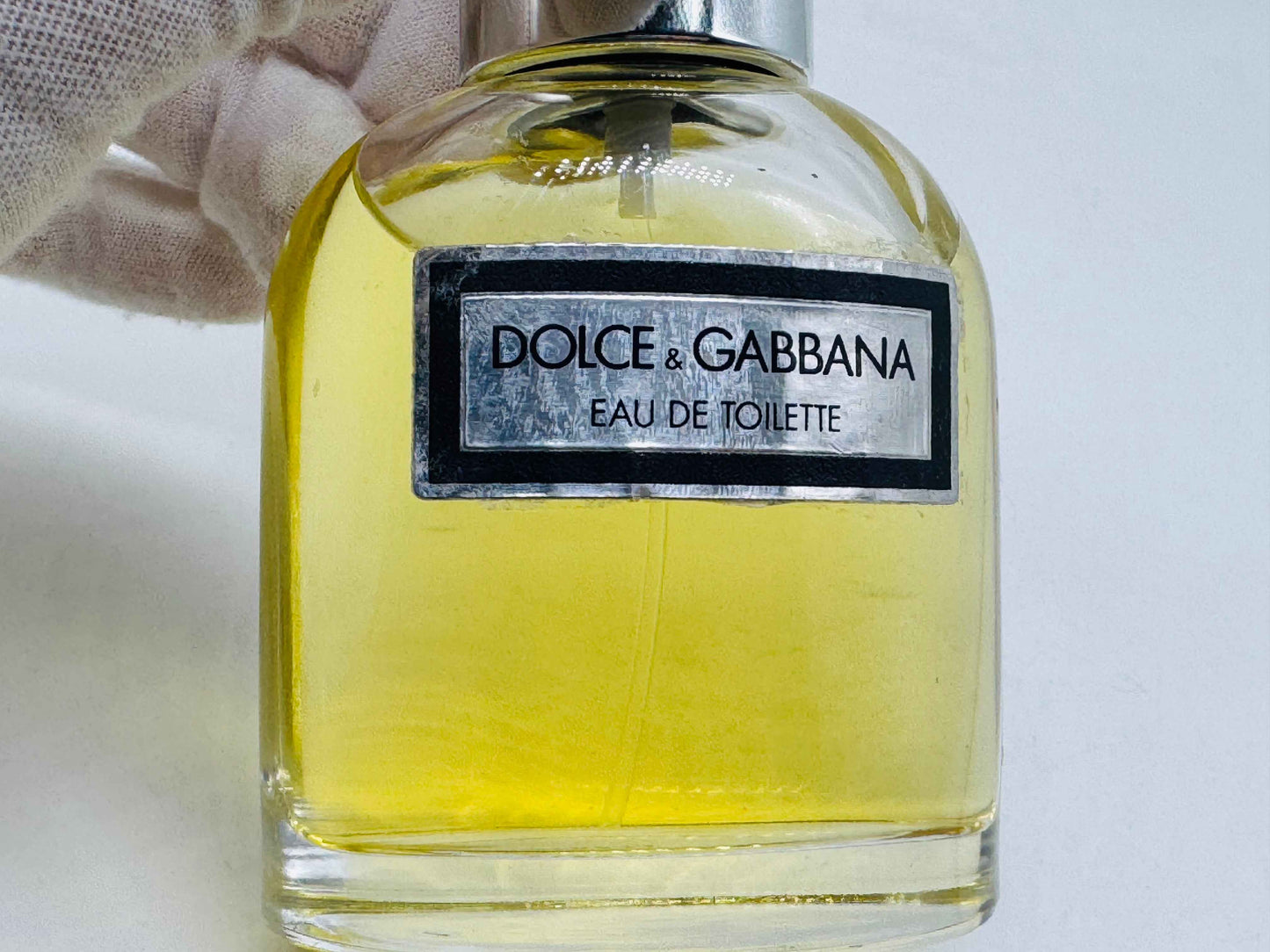 Flacone di profumo Dolce & Gabbana Pour Homme in vetro con etichetta elegante e liquido giallo