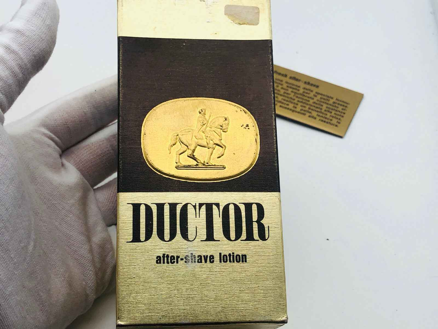 Flacone di lozione dopobarba Ductor Pour Homme con design elegante e logo dorato