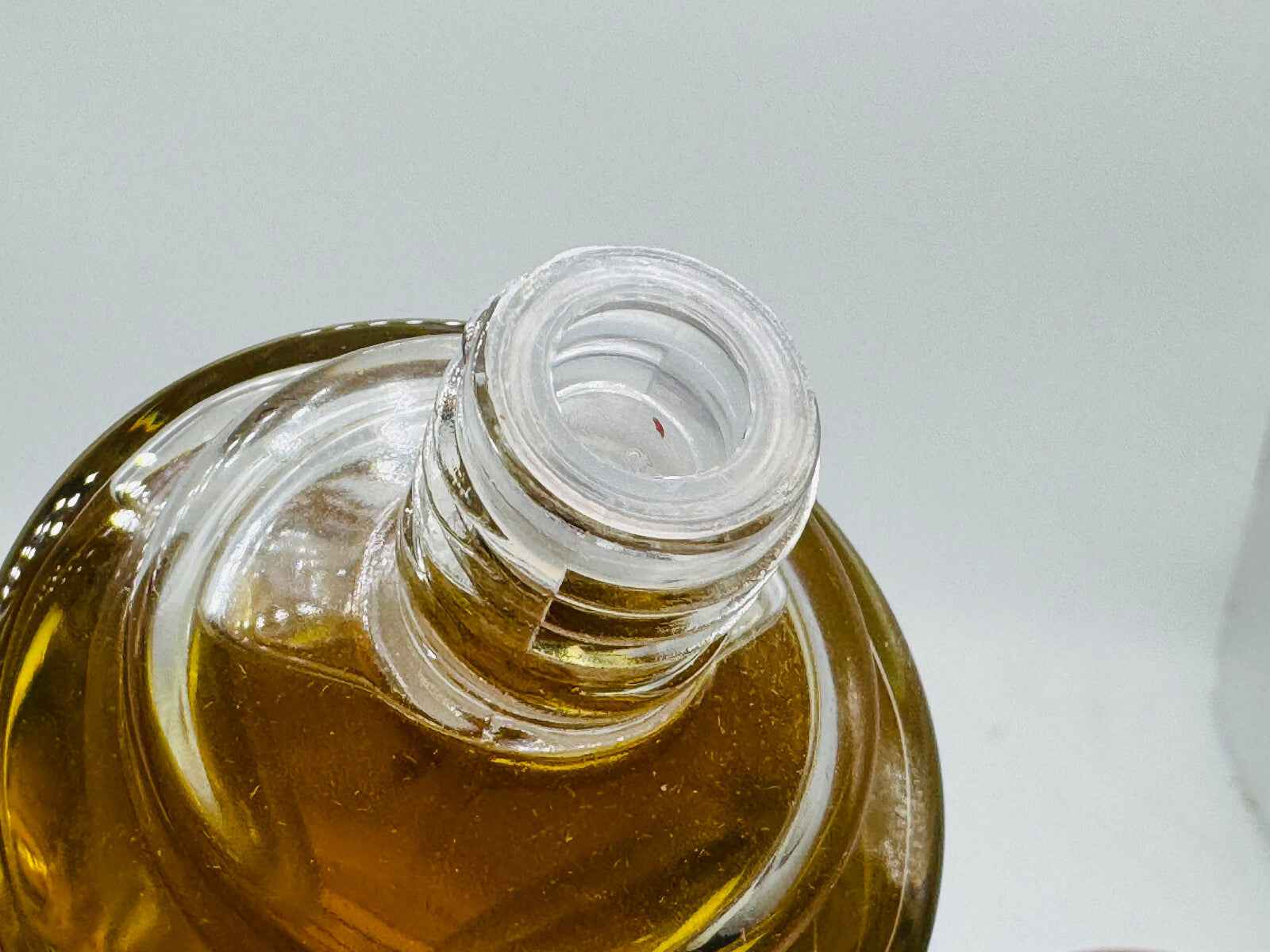 Dettaglio della bottiglia di Eau Folle Laroche Vintage con collo di vetro trasparente e liquido ambrato