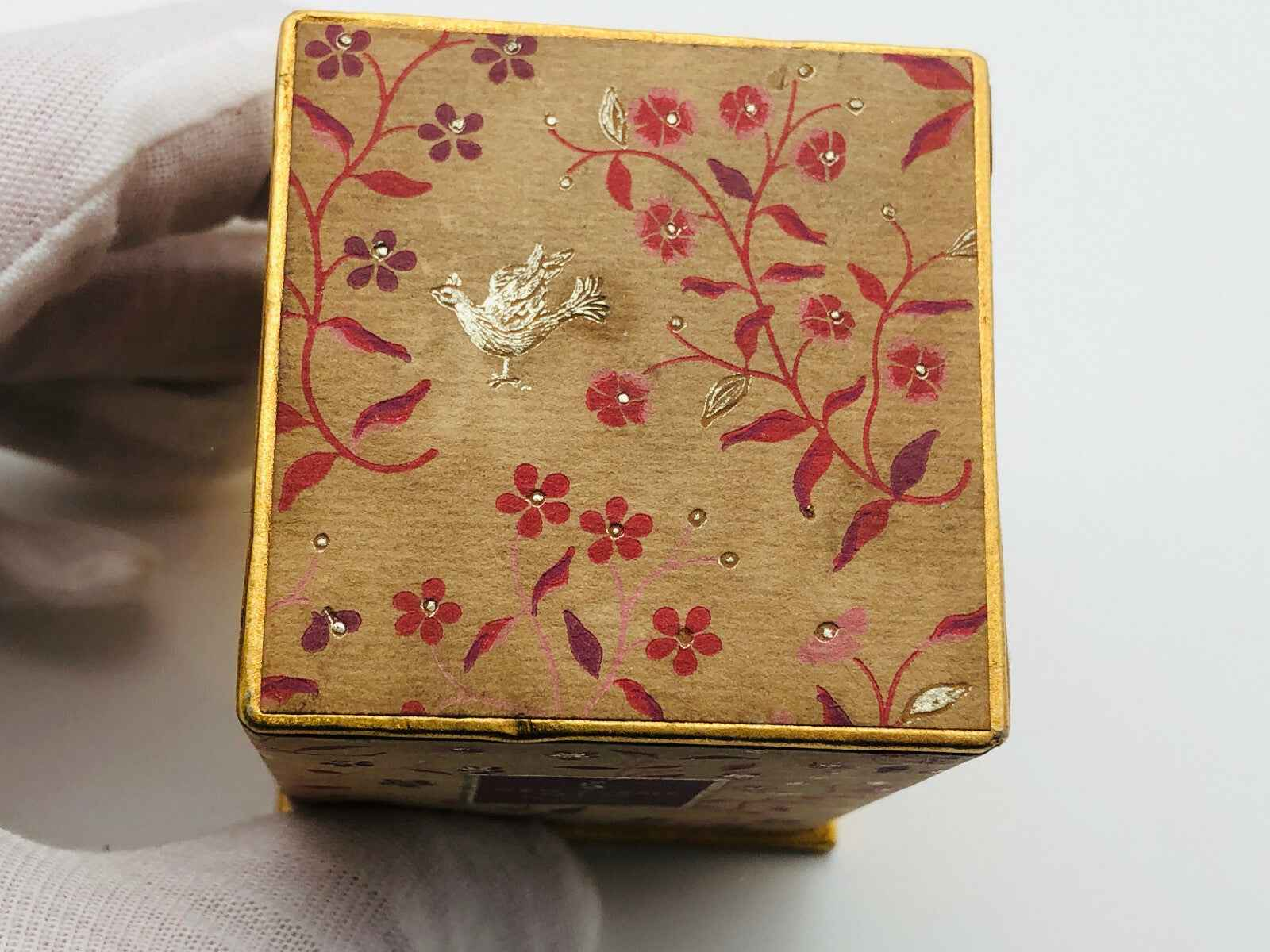 Scatola del profumo Flame Of Hope Parfum con design floreale in oro e colori vivaci