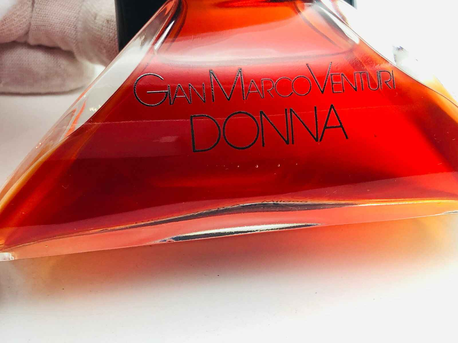 Bottiglia di profumo Gianmarco Venturi Donna Vintage con riflessi arancioni e design elegante