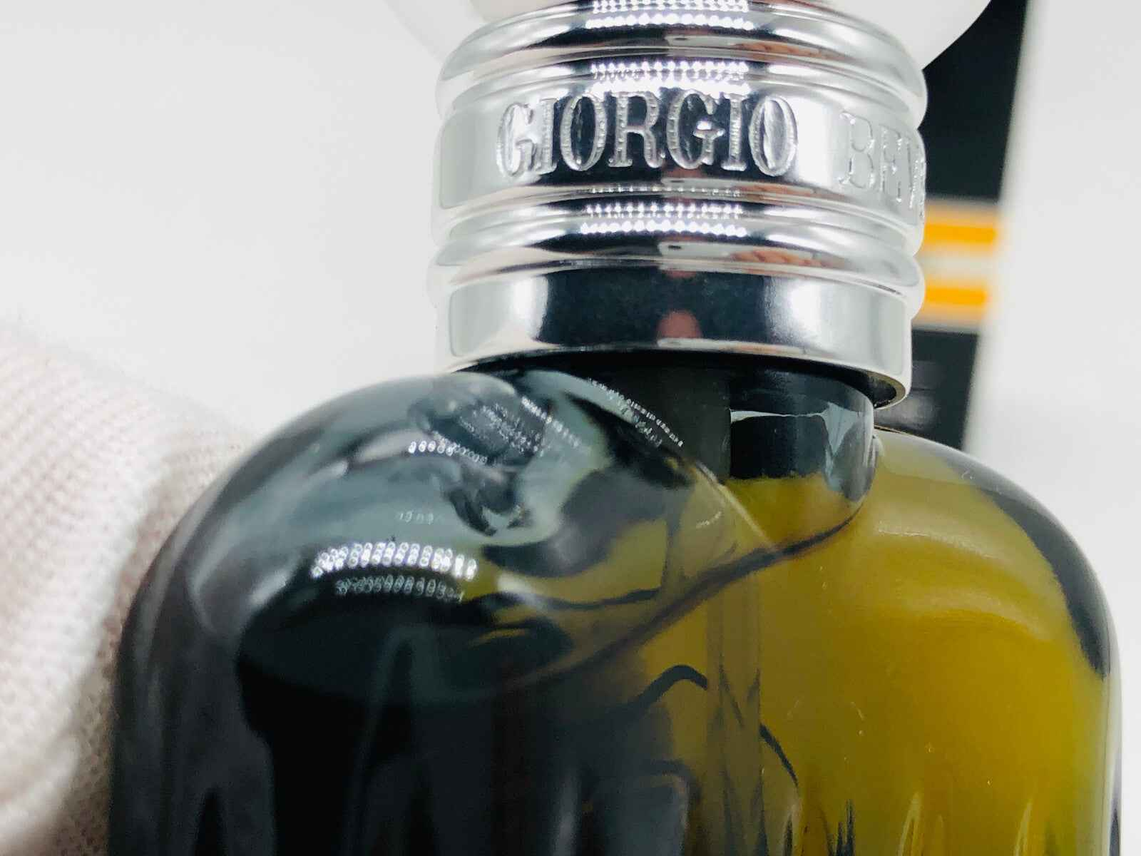 Flacone di profumo Giorgio Beverly Hills Homme con design elegante e dettagli metallici.