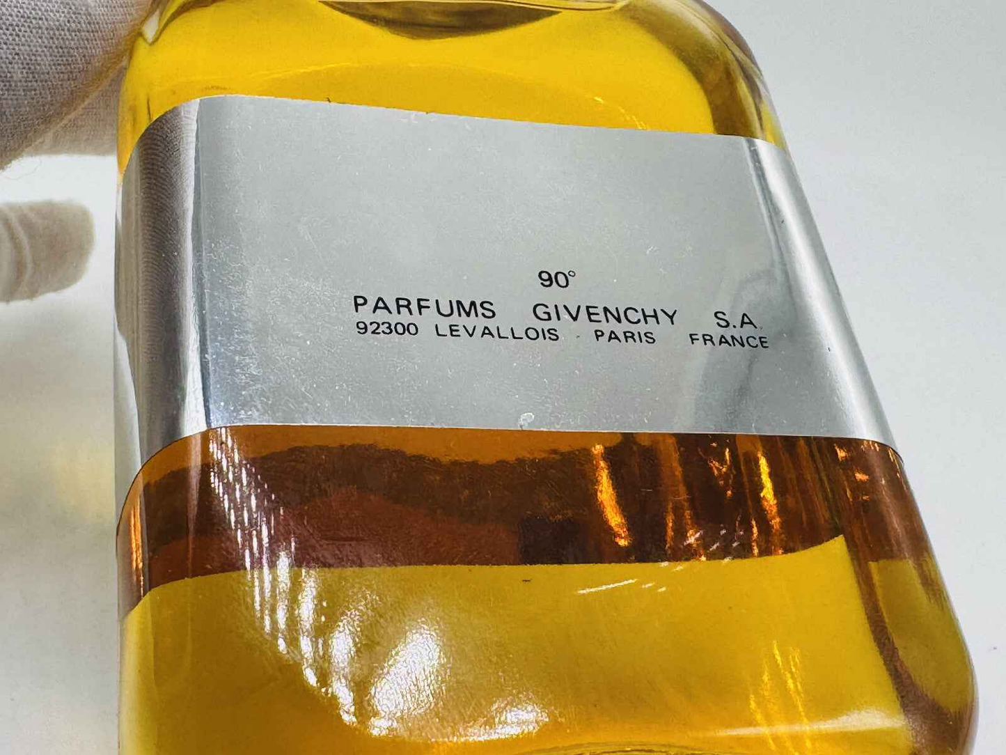 Flacone di profumo Givenchy Gentleman Vintage con etichetta chiara e tonalità dorata
