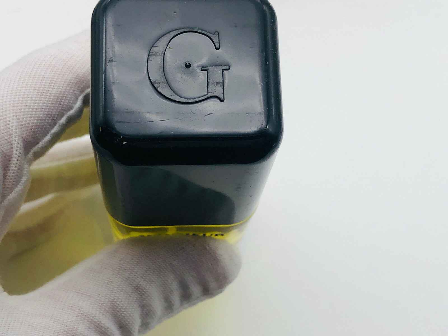 Evidenza del tappo di un profumo Givenchy Monsieur Vintage con logo G in rilievo