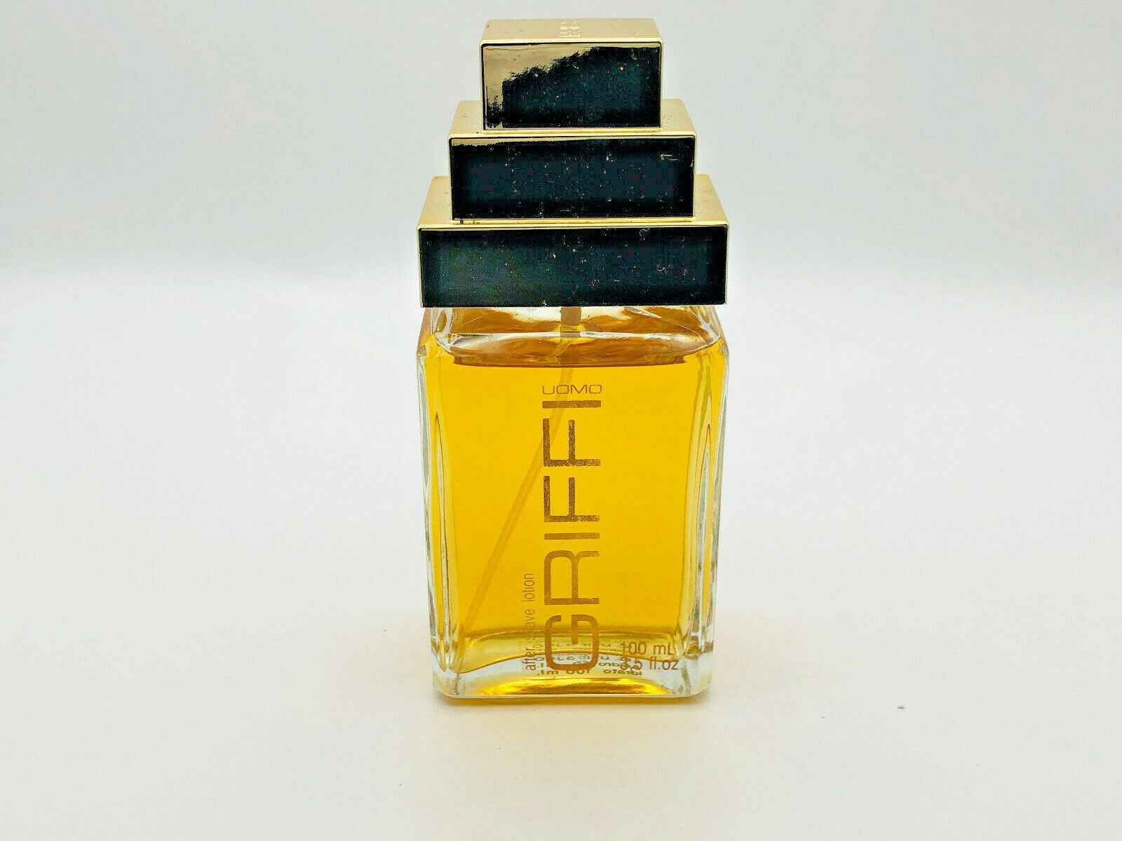 Profumo GRIFFI Uomo Vintage in bottiglia trasparente con tappo dorato e tre blocchi, fragranza elegante