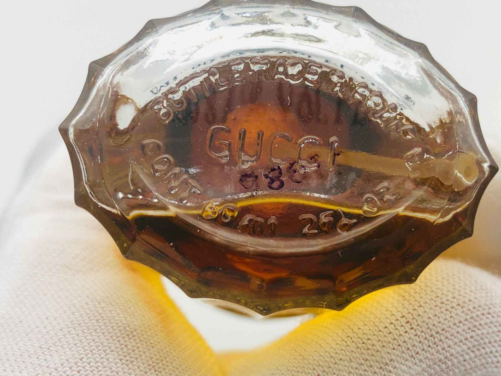 Bottiglia di PROFUMO EAU DE GUCCI VINTAGE con etichetta in rilievo sul fondo e design elegante