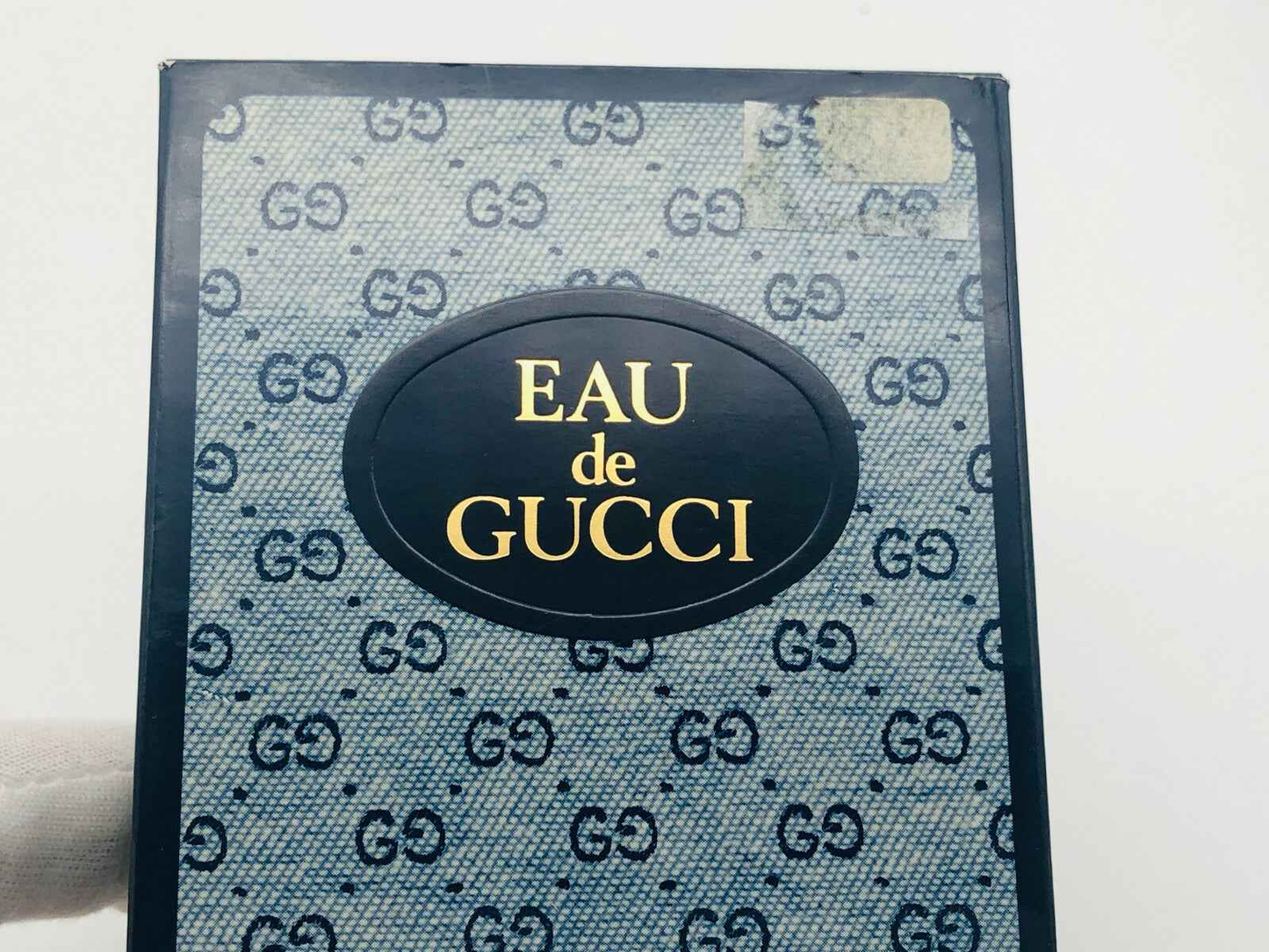 Scatola di profumo Eau de Gucci Vintage con logo Gucci su sfondo blu
