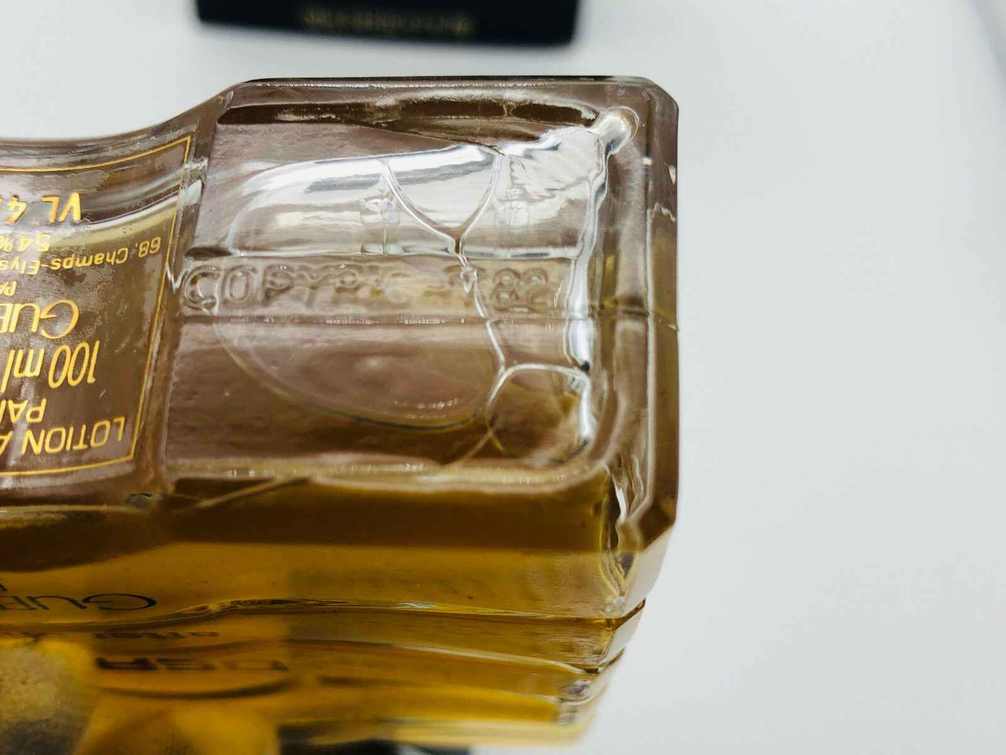 Dettaglio della bottiglia di profumo Derby Guerlain con chiusura unica e design elegante