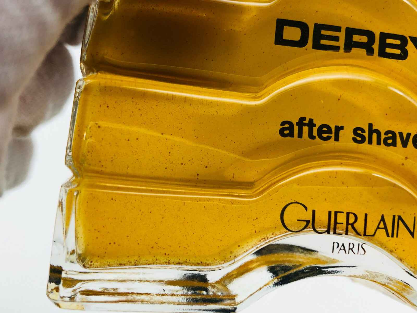 After shave Derby Guerlain in bottiglia trasparente con etichetta gialla e dettagli eleganti