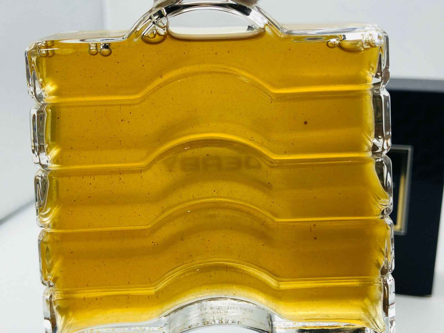 Profumo Derby Guerlain in bottiglia trasparente con liquido dorato per un'atmosfera elegante