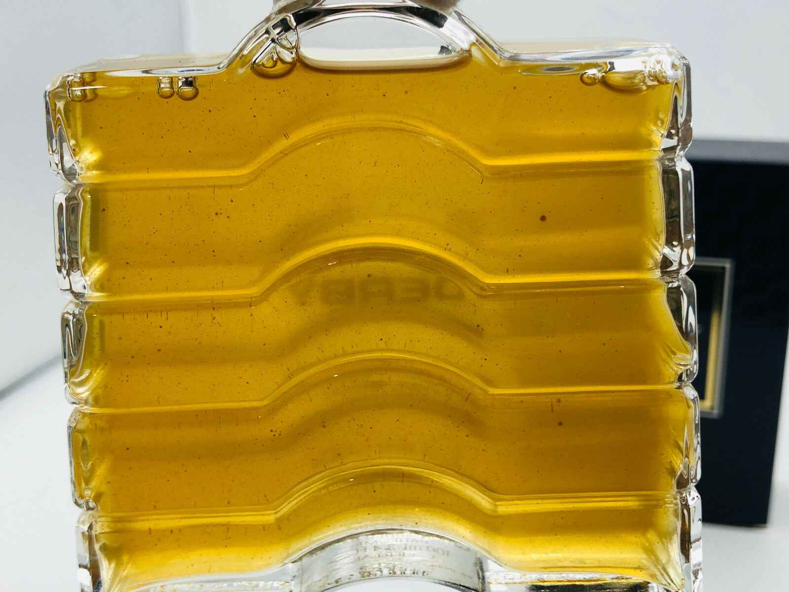 Profumo Derby Guerlain in bottiglia trasparente con liquido dorato per un'atmosfera elegante