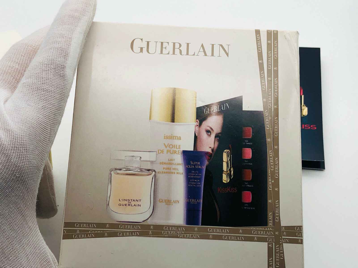Scatola di prodotto Guerlain con instant Guerlain Vintage e vari cosmetici in evidenza