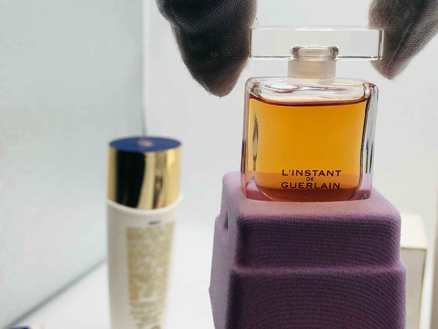 Flacone di profumo L'Instant Guerlain Vintage con elegante design e tonalità dorate