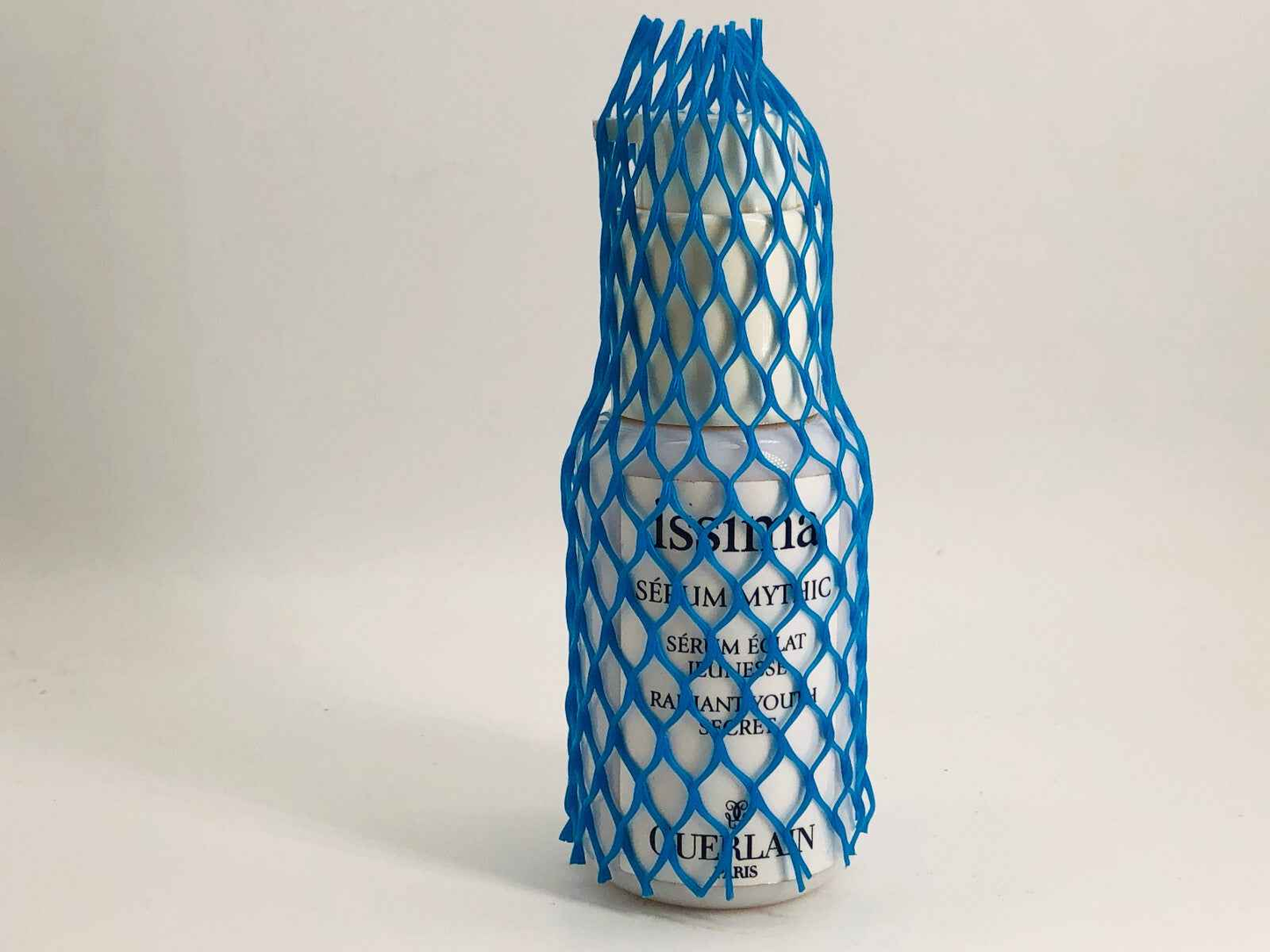 Guerlain Issima Serum in a protective netting, promoting radiant and youthful skin
