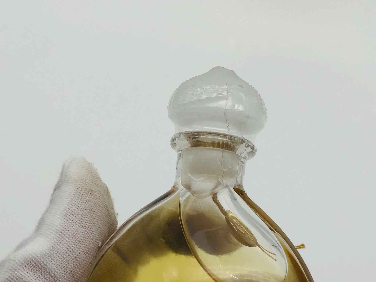 Dettaglio di flacone di profumo Guerlain Mitsouko Vintage con tappo decorativo in vetro