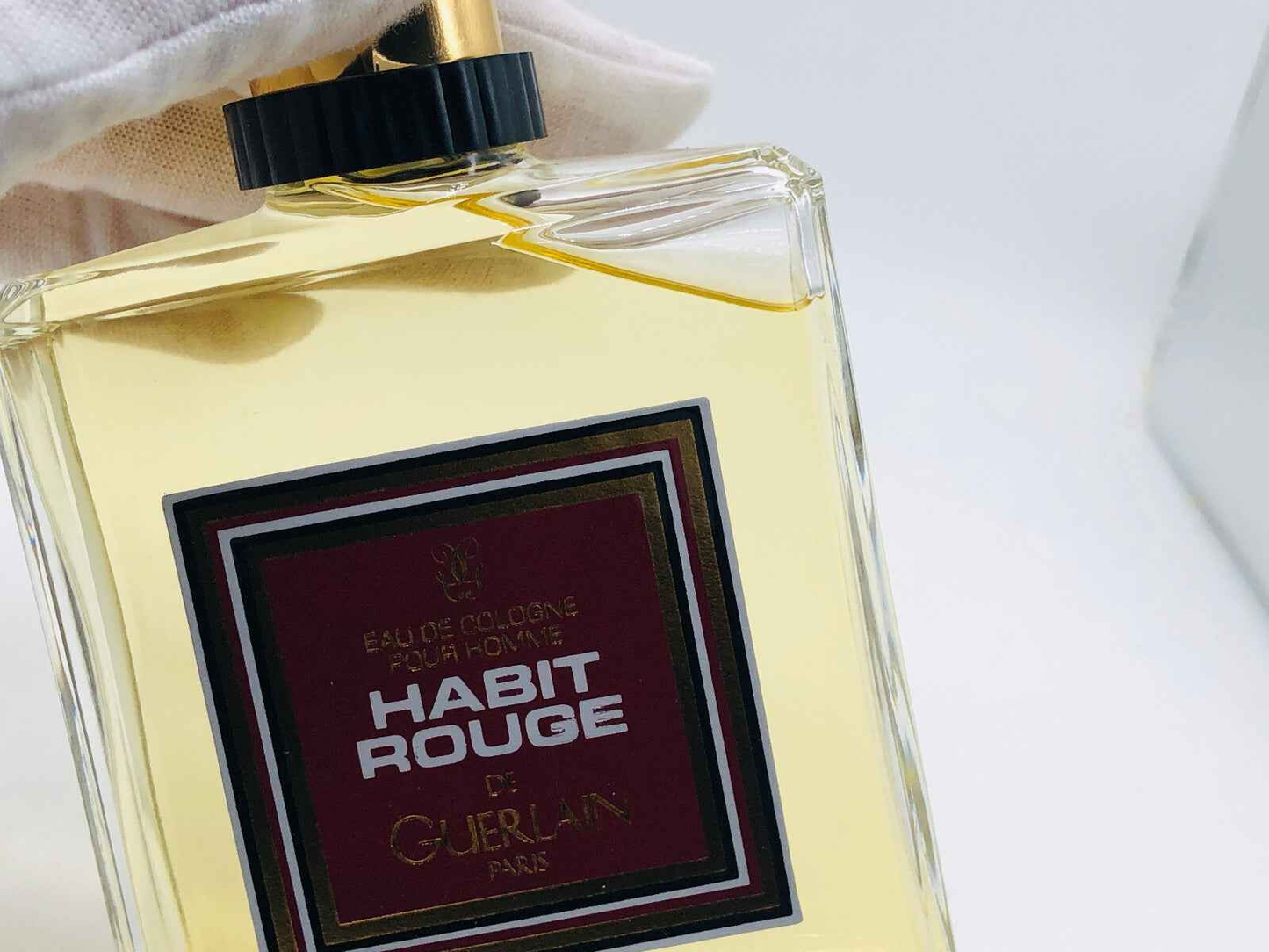 Flacone di profumo Guerlain Habit Rouge Vintage con etichetta elegante e design sofisticato