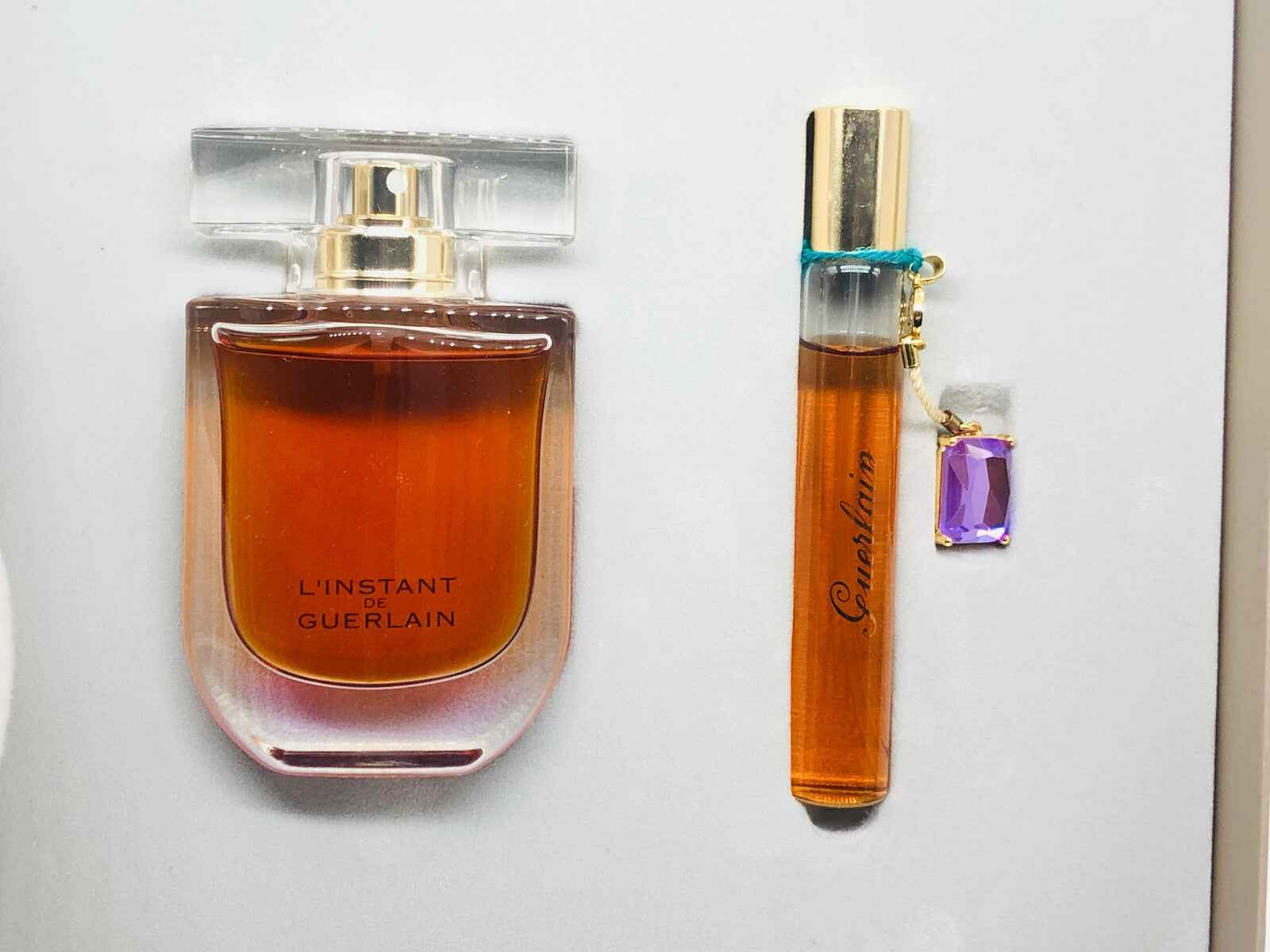 Profumo Guerlain L'Instant in bottiglia grande e flacone miniatura con tappo elegante