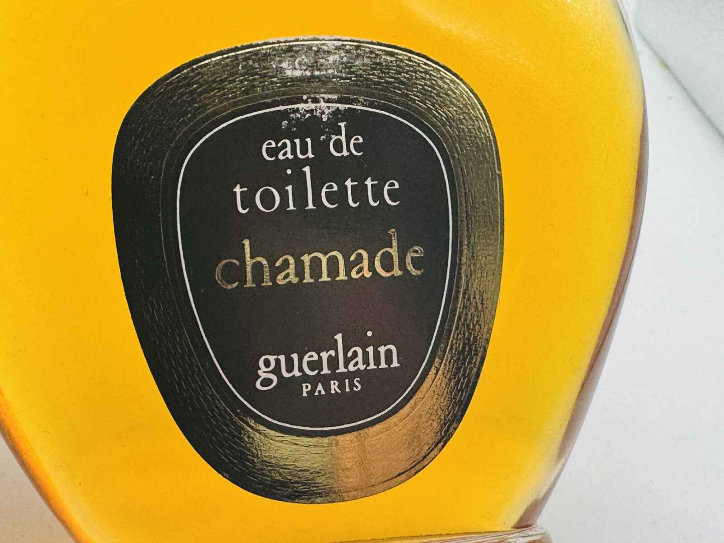 Bottiglia di profumo vintage Guerlain Chamade con etichetta in oro e design eleganza