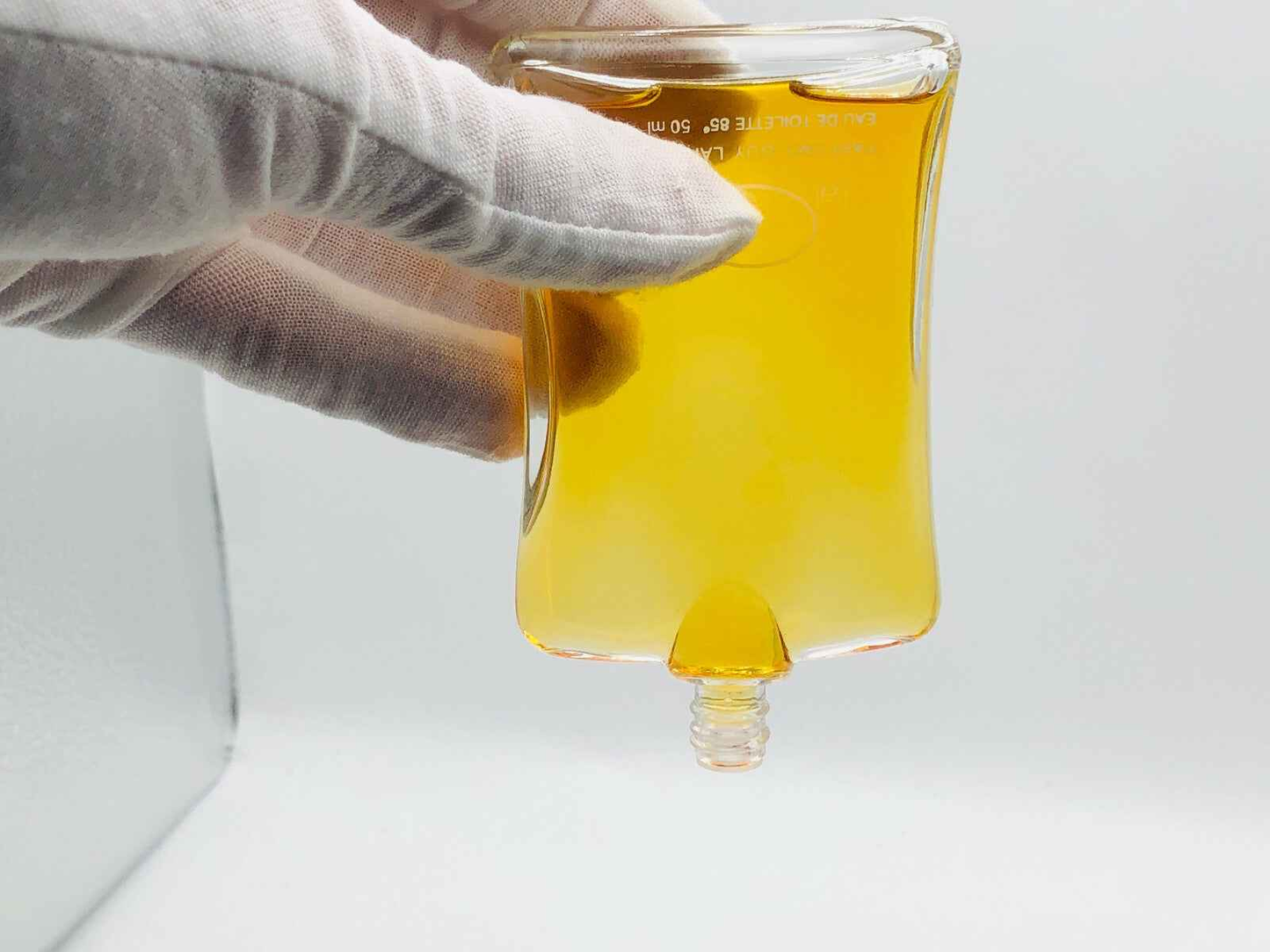 Flacone di profumo J Ai Ose di Guy Laroche con un design elegante e liquido dorato
